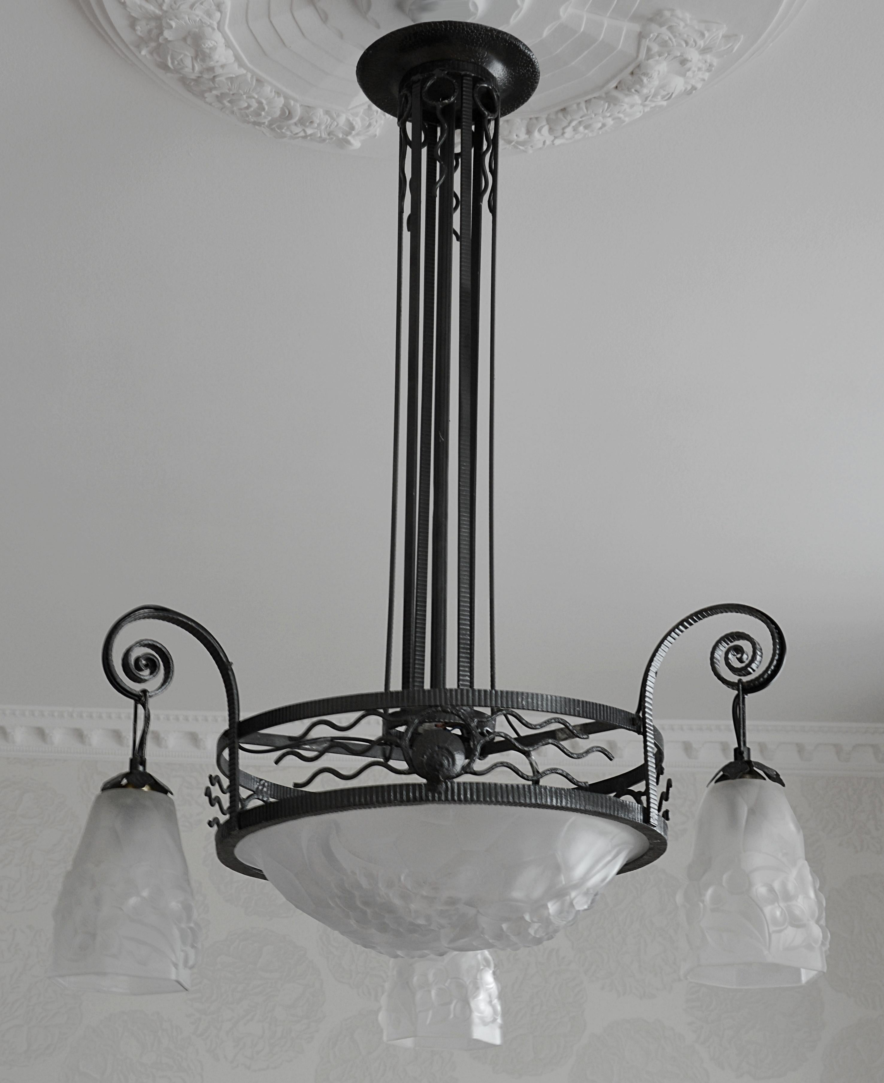 French Art Deco chandelier by Degue and Vasseur, France, late 1920s. Thick molded glass lampshades with a hydrangea pattern by Degue (Compiegne) hanged on a wrought iron metal frame by Marcel Vasseur, 22 rue Mousset-Robert in Paris. Measures: Height