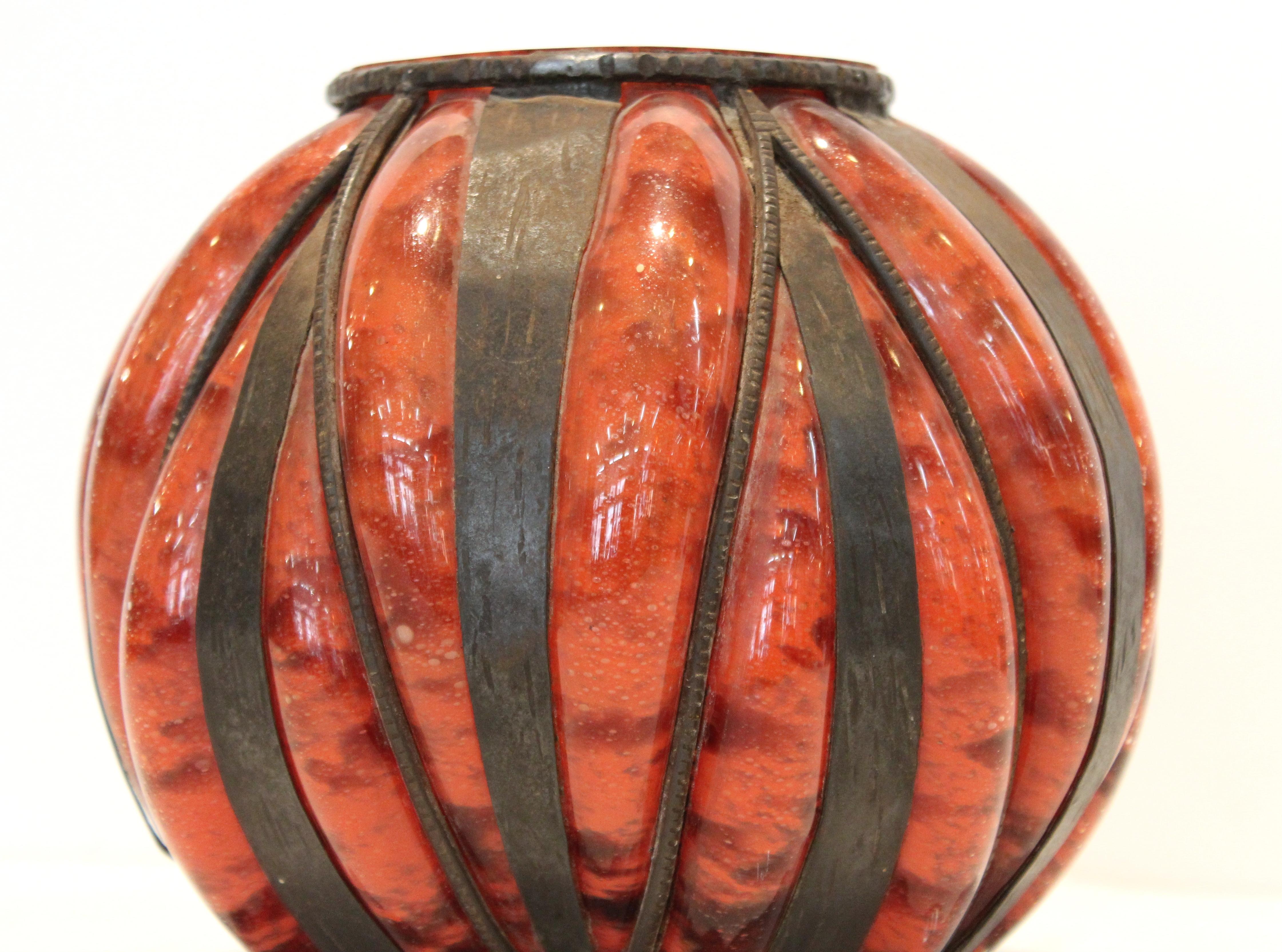 Französische Art-Déco-Glasvase, die Degué zugeschrieben wird und wahrscheinlich Mitte der 1920er Jahre hergestellt wurde. Das Stück besteht aus mundgeblasenem Glas, das in eine Struktur aus handgeschmiedetem Eisen eingebettet ist. Auf dem Boden