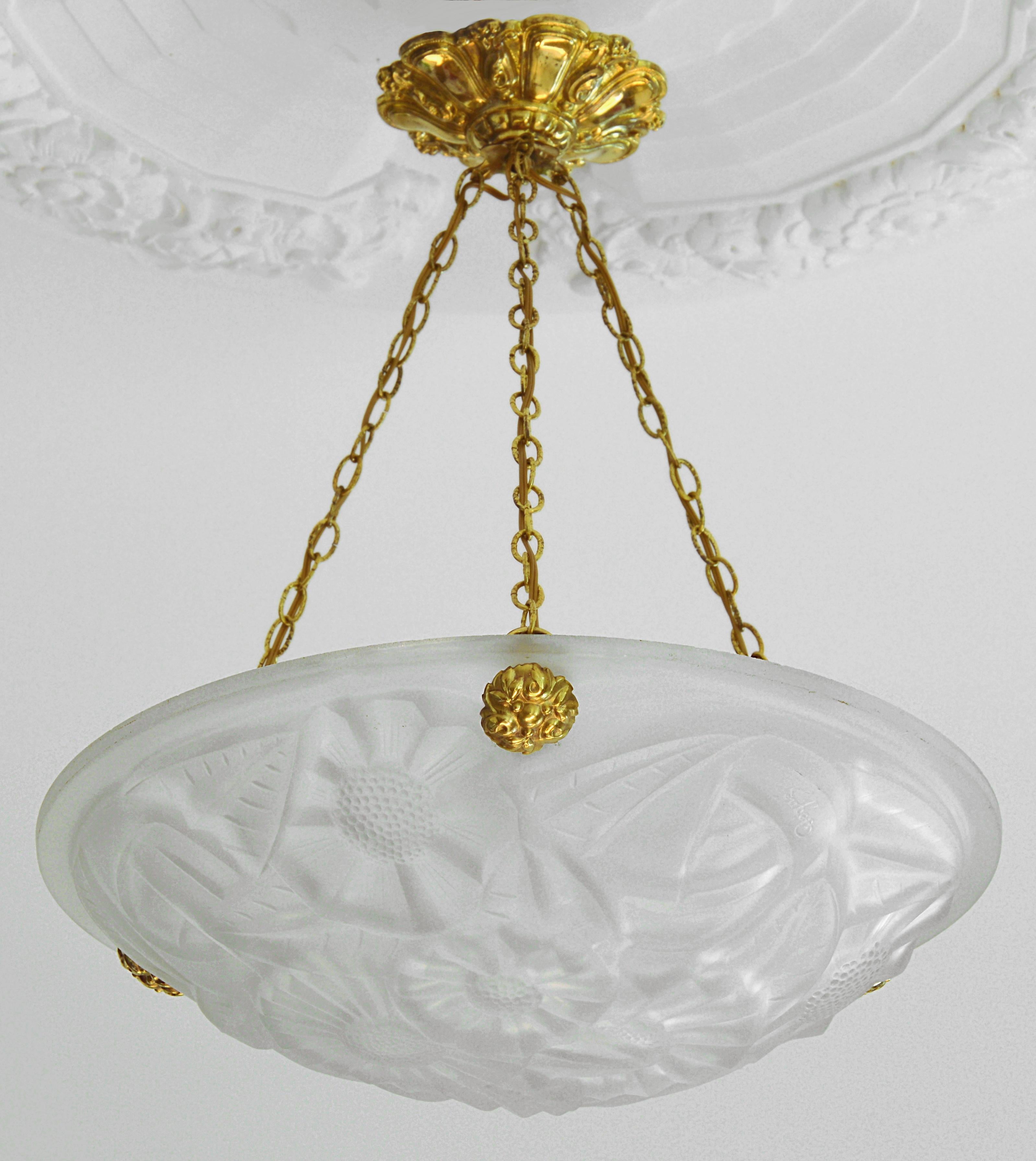 French Art Deco chandelier by Degue, Compiegne, France, late 1920s. Thick molded glass shade showing a floral pattern. Stamped brass fixture.
Signed 