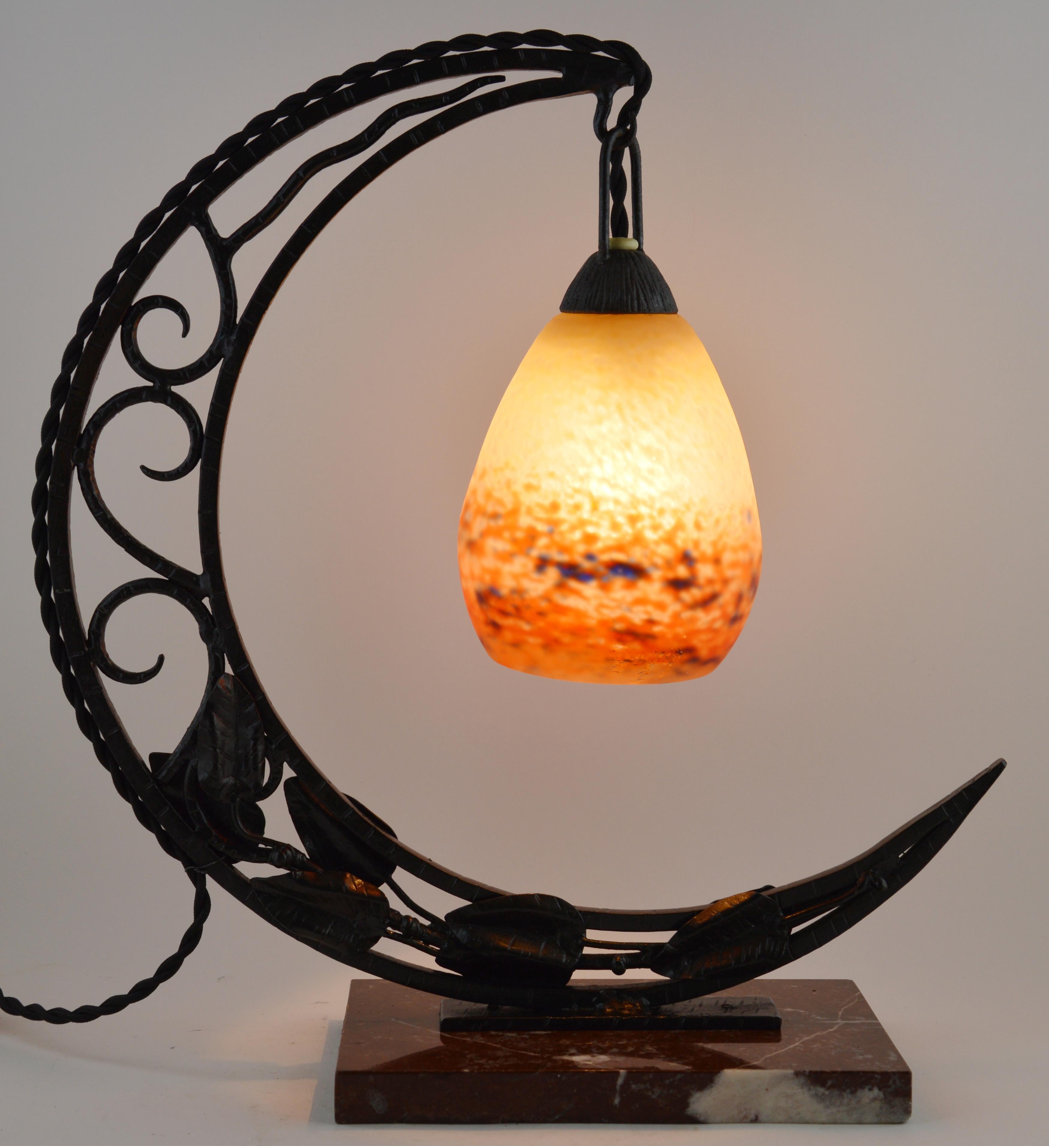 Large French Art Deco table lamp by Degué (Compiegne), France, 1920s. This lamp has a blown glass shade on its wrought iron frame crescent-shaped. Measures: Height 15.2