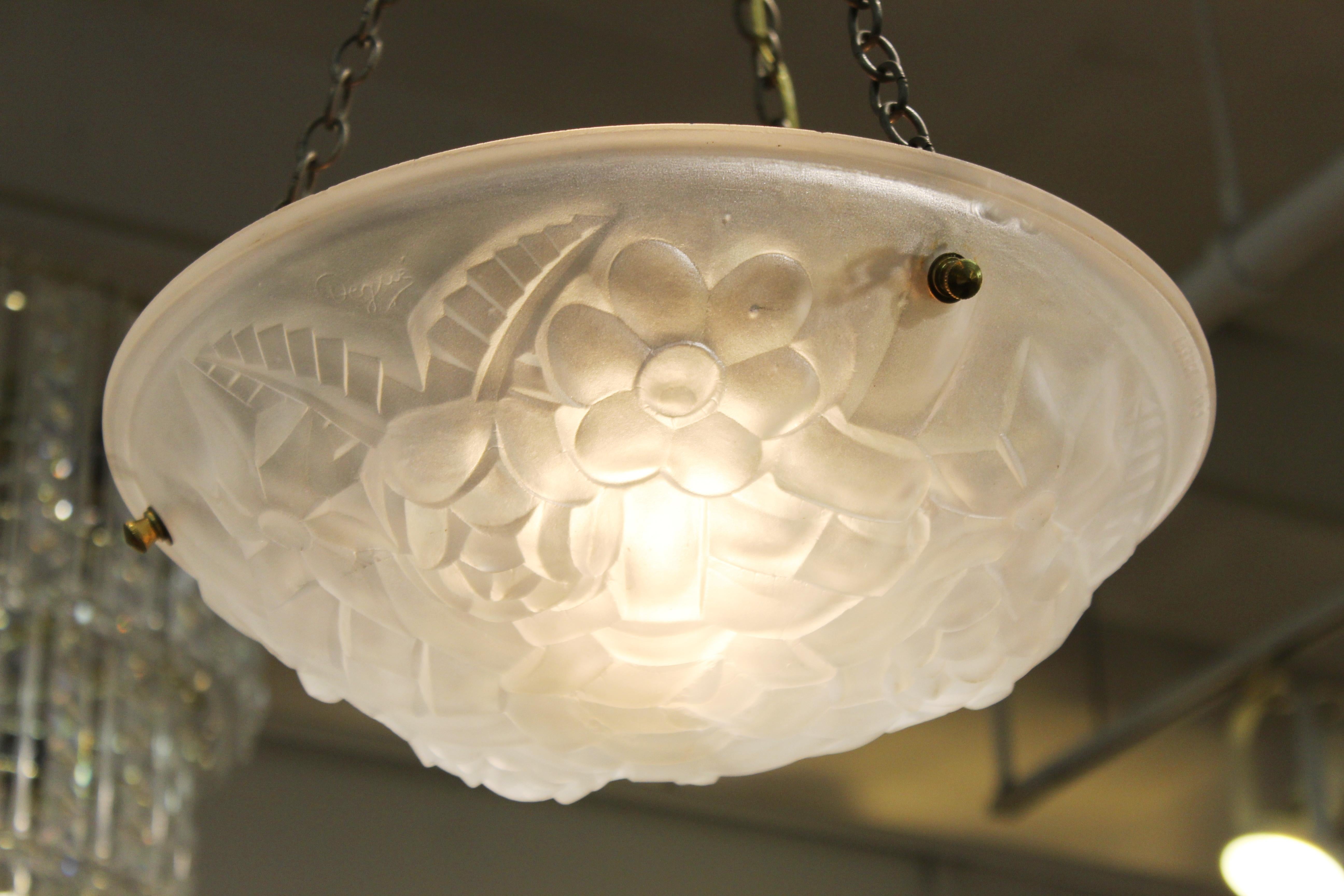 French Art Deco ceiling pendant with a frosted glass bowl pendant with floral themed relief, made by Degué in France during the 1920s. The bowl is suspended by three brass chains from a canopy piece and the bowl itself has never been used before.