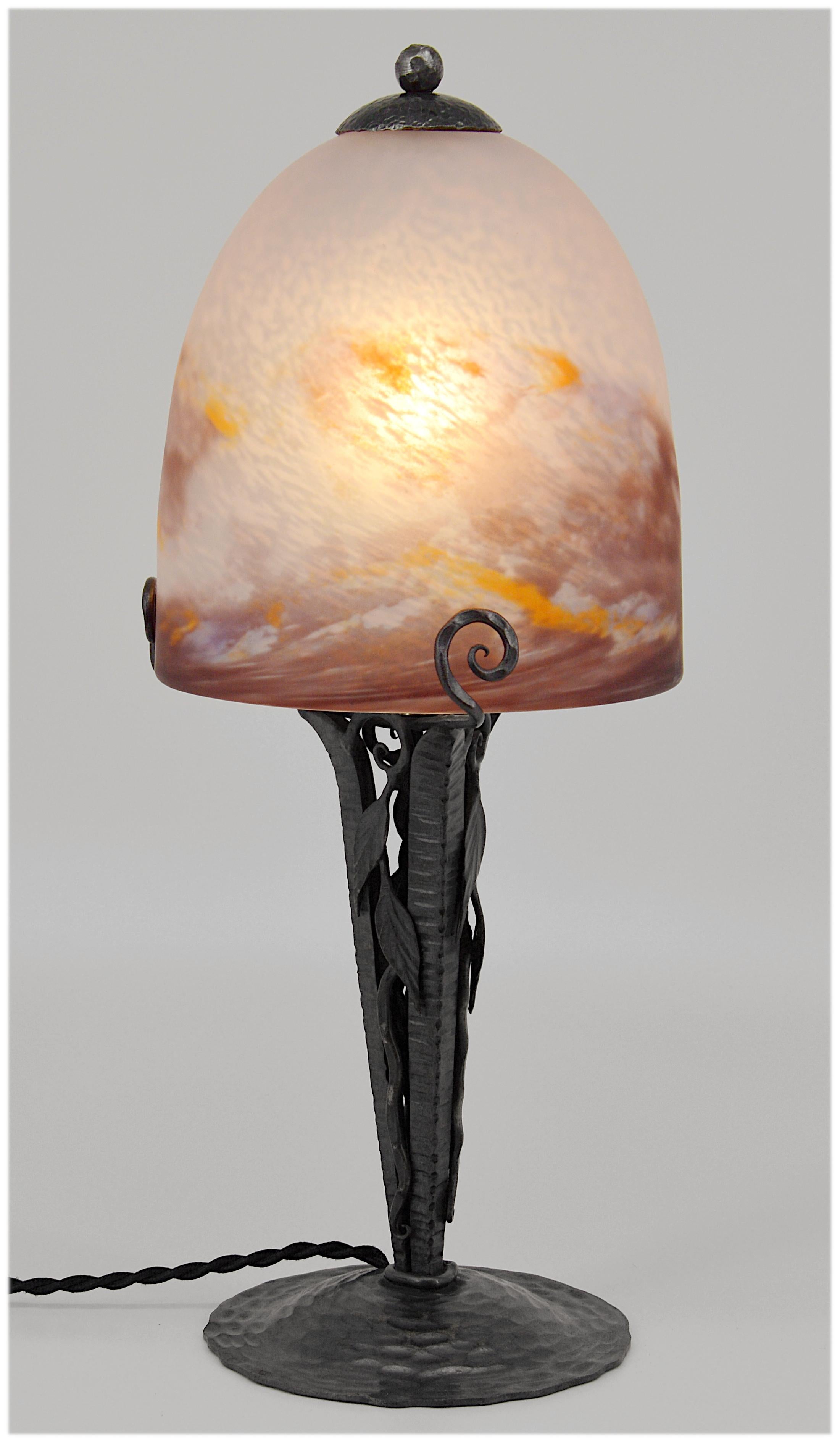 Art Deco table lamp by Degue (Compiegne), France, late 1920s. Mottled glass shade, powders are applied between two layers, that comes on its period wrought iron base. Colors: Purple, ochre and white. Measures: Height 15