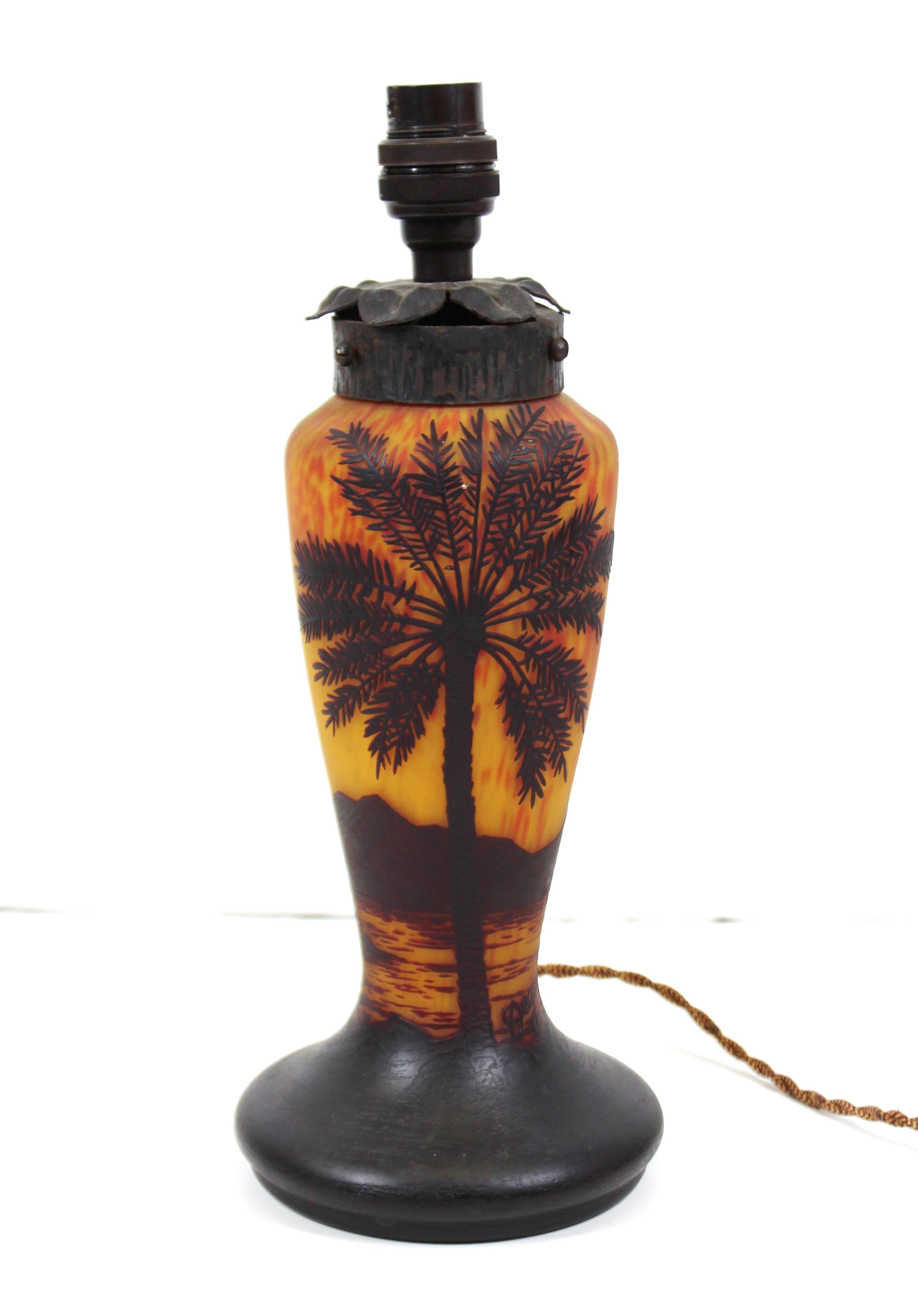 French Art Nouveau diminutive table lamp in cameo glass made by Degué. The piece has a palm tree motif and delicate wrought iron mount. Signed Degué near the base of the palm tree. In great antique condition with age-appropriate wear and use.