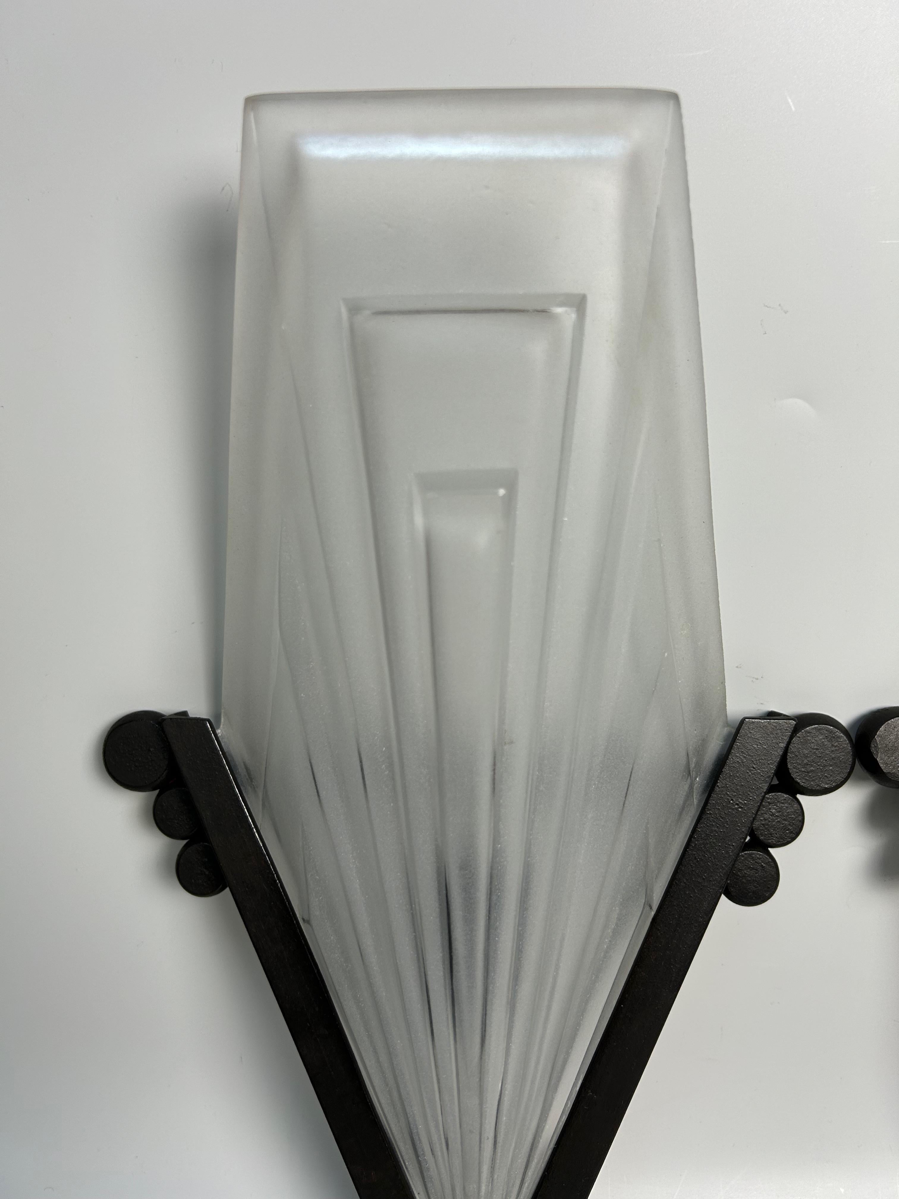 Pareja de apliques art déco circa 1930.
Armazón de hierro forjado con pátina negra.
Placas de vidrio moldeado prensado con decoración geométrica firmadas Degué y Compiegne.
Electrificado y en perfecto estado.

Altura total: 34 cm
Anchura: 22.5