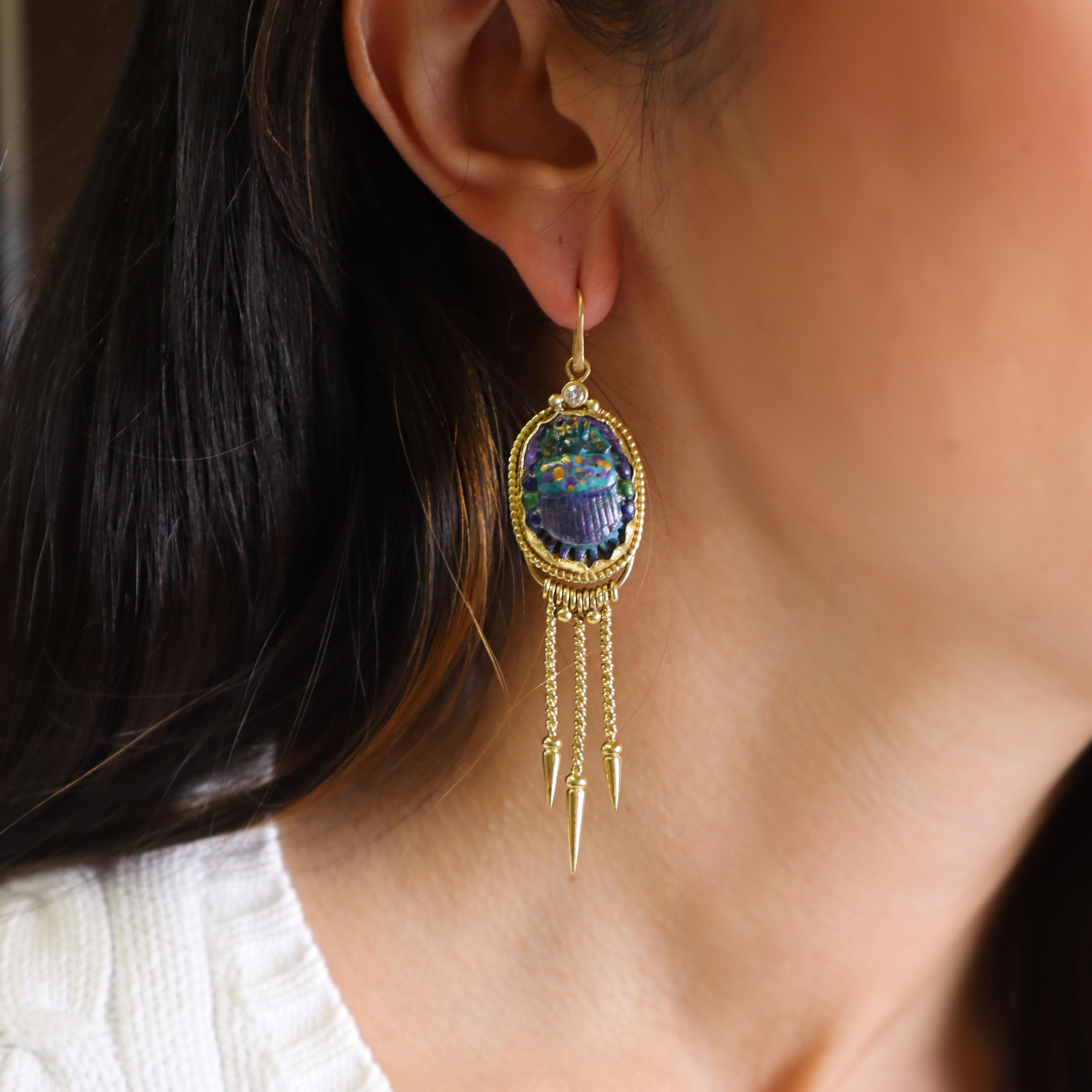 Introducing the exquisite DEIRDRE FEATHERSTONE Diamonds and Enamel Scarab Beetle drop earrings, crafted in 18kt yellow gold. Each earring features a beautifully detailed scarab beetle adorned with vibrant purple, gold, blue, and green enamel,