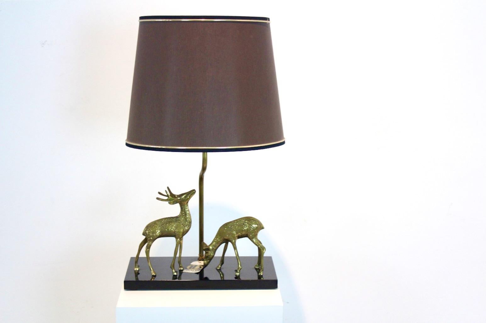 Exclusive, unique and exotic Brass Table Lamp with a deer sculpture, produced by Deknudt Belgium in the 1970’s. The lamp comes with the Original label from ‘Lustrerie Deknudt’. It comes also with the original shade and a solid black wooden base and