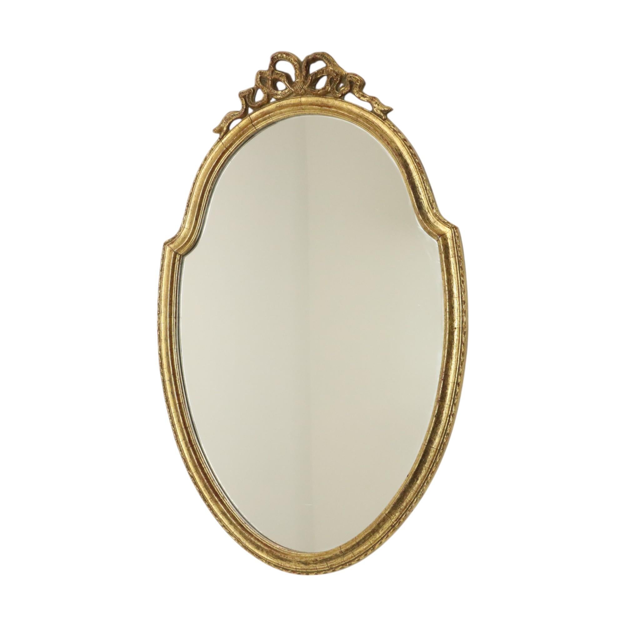 Beautiful and charming classic mirror with ribbon and bow at the top, made of gold leaf gilded wood, by Deknudt, marked and numbered on the back, circa 1960s, Belgium.

Quality mirror in classic style, by Belgian house Deknudt, specialized in