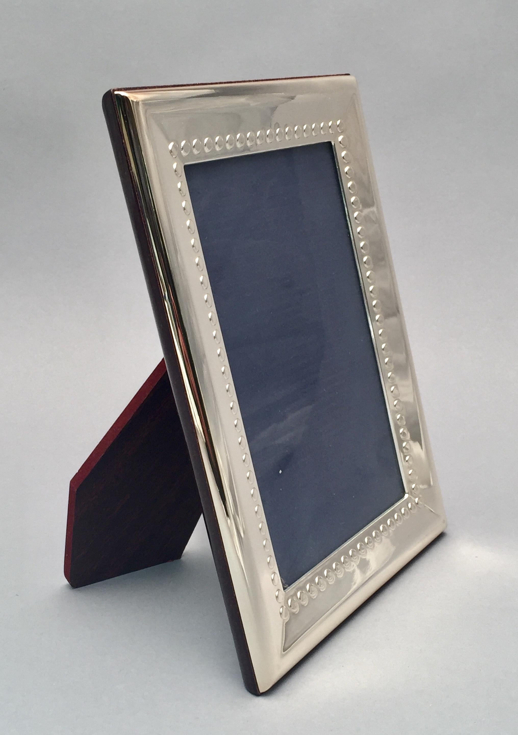 Sterling silver picture frame made in Italy by Del Conte, 5 3/4 x 3 3/4. Designed with a raised polka dot border, glossy wooden back and wooden easel. Can be used as a great frame for wedding pictures, to give as a gift to a friend, or to enhance