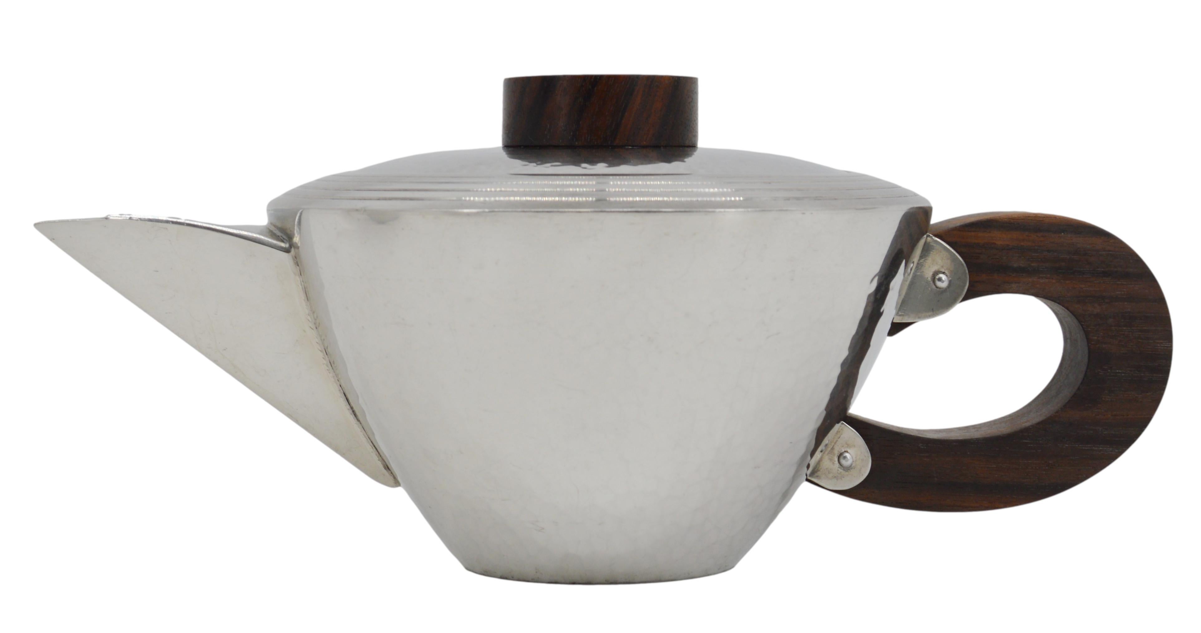 French Art Deco Pewter Tea Set by René Delavan, Paris, Late 1920s. This elegant pewter tea set, crafted by René Delavan in Paris during the late 1920s, beautifully exemplifies the Art Deco style. The hammered pewter surfaces are complemented by