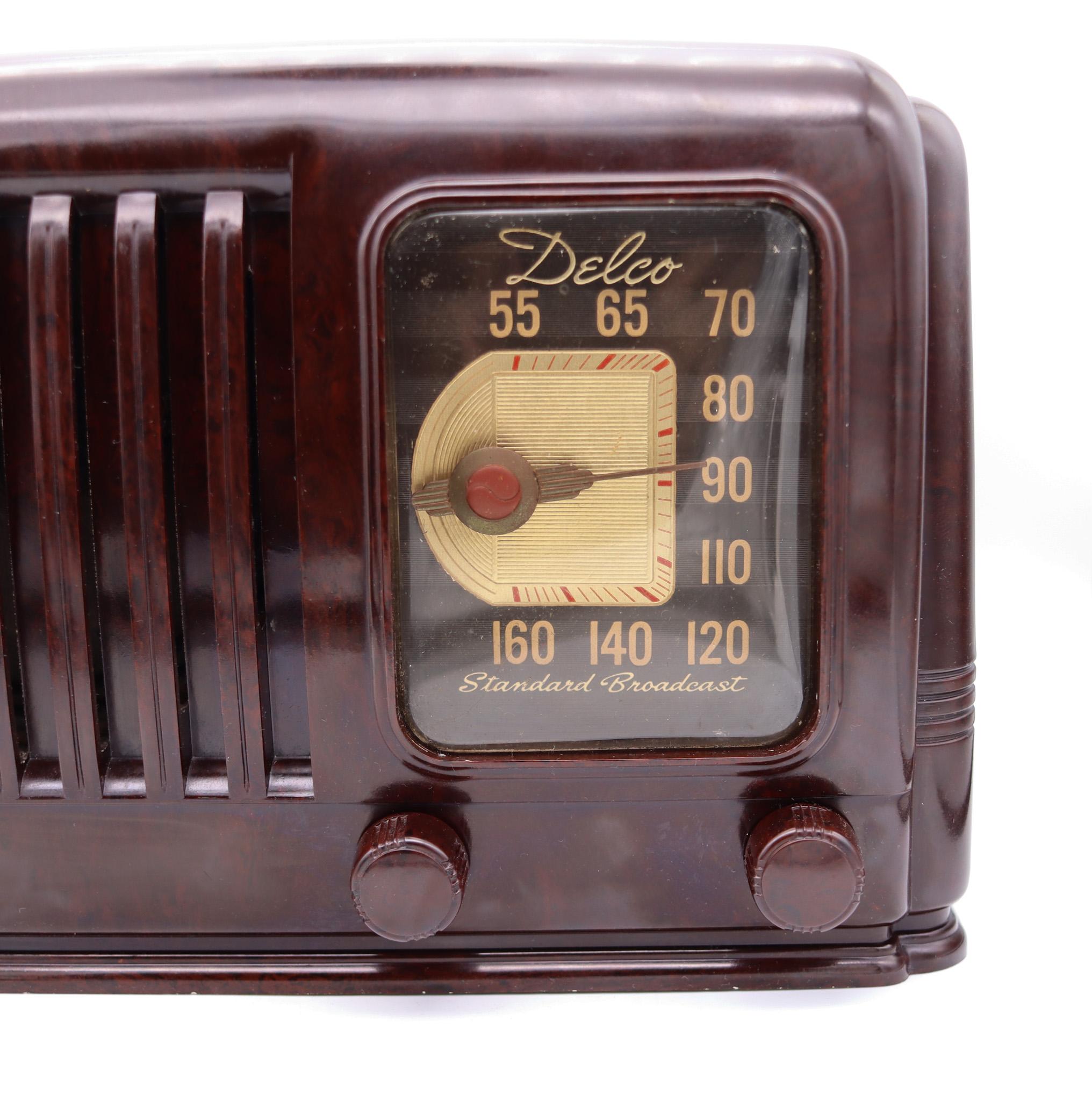 An Art Deco tube radio designed by Delco.

Here we are offering an absolutely stunning 1941 Delco model R-1171 tabletop tube radio. Featuring a gorgeous dark brown marbled Bakelite cabinet, attractive dial, louvered grill, built in loop antenna and