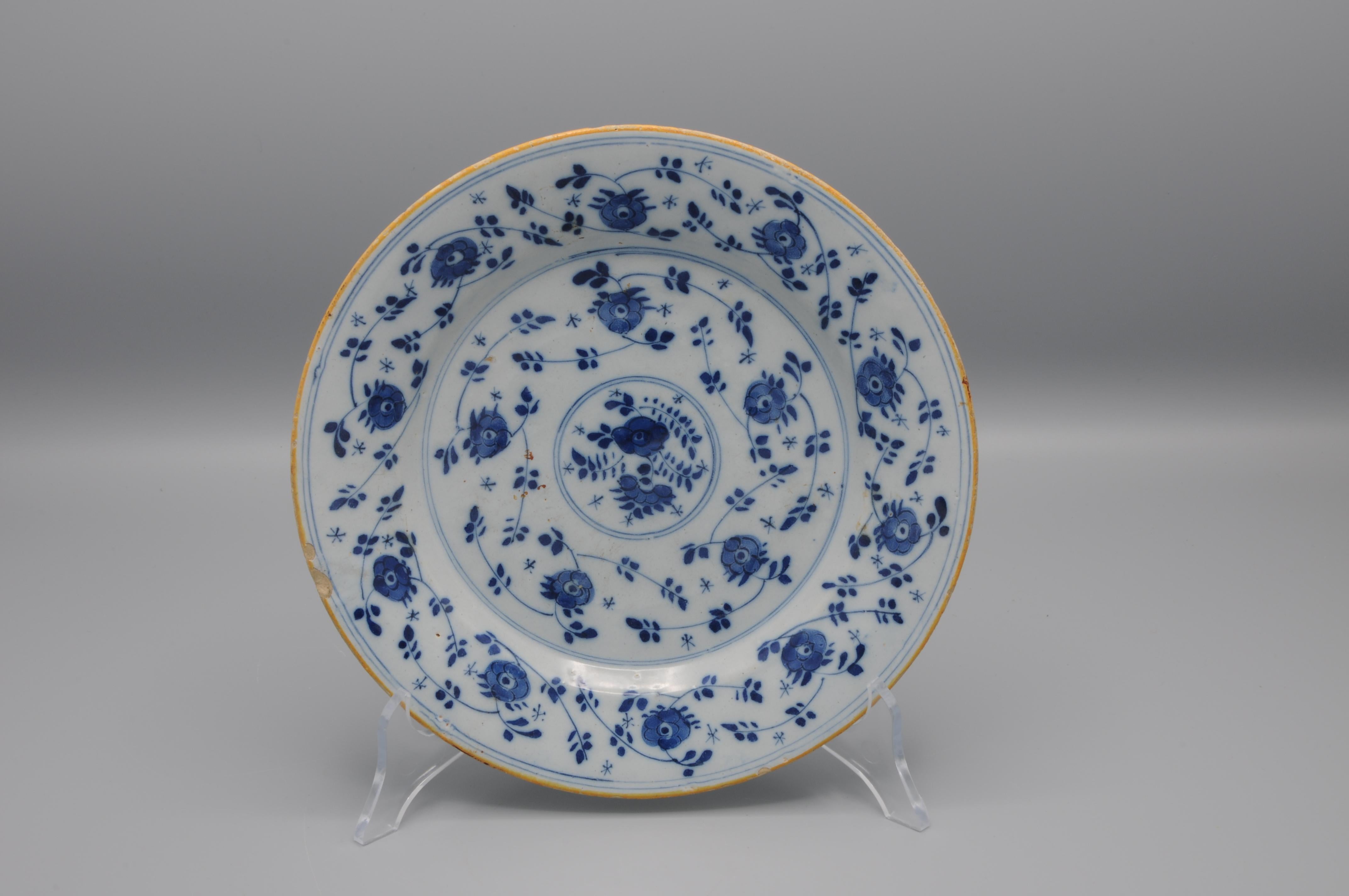 Dutch Delft Chinoiserie plate with a 'Mille Fleurs' decoration of flower buds and flower sprays. 

Good condition: light chipping and some usual wear to the rim.