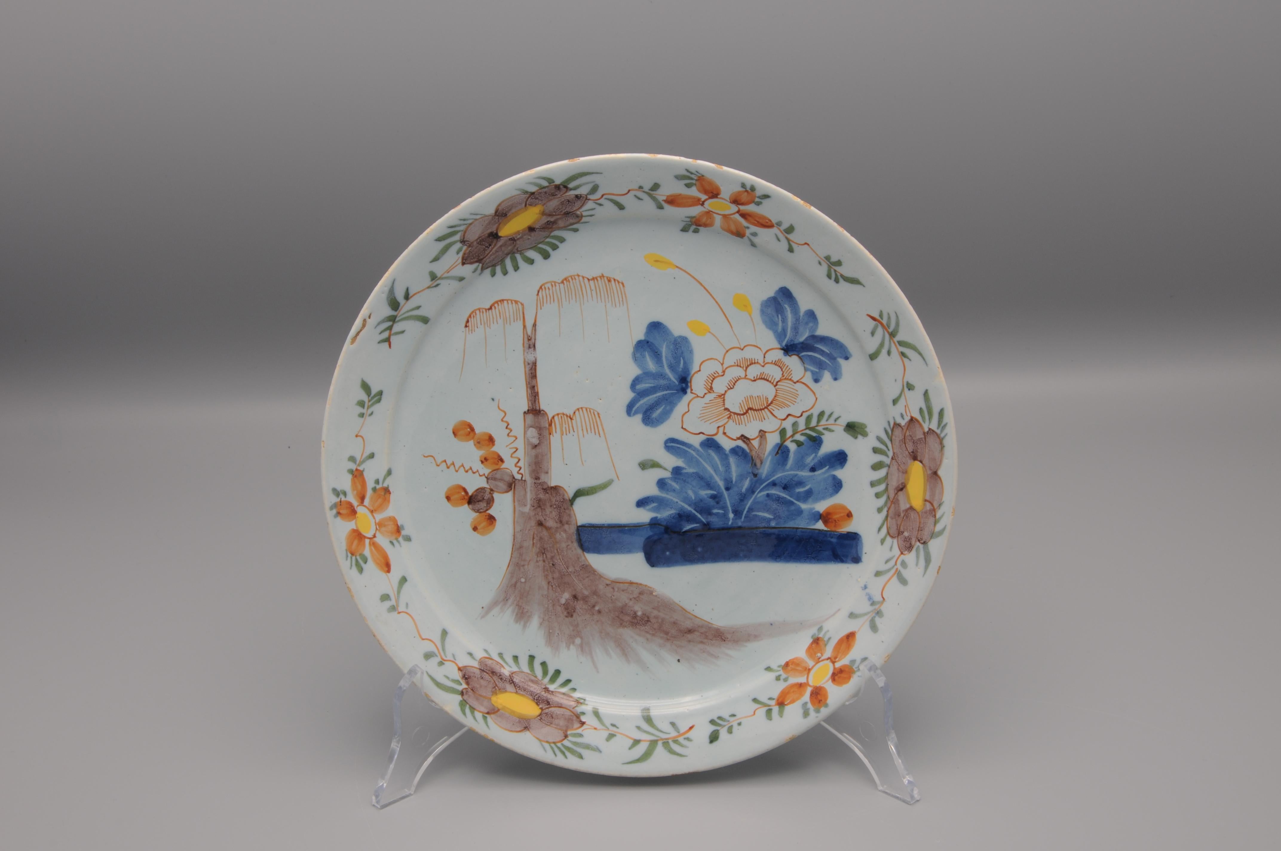 Polychrome Dutch Delft Chinoiserie plate featuring blossoming peony and a willow tree
Beautiful chinoiserie alternating flowers on the rim

Very good condition: usual wear to the rim.