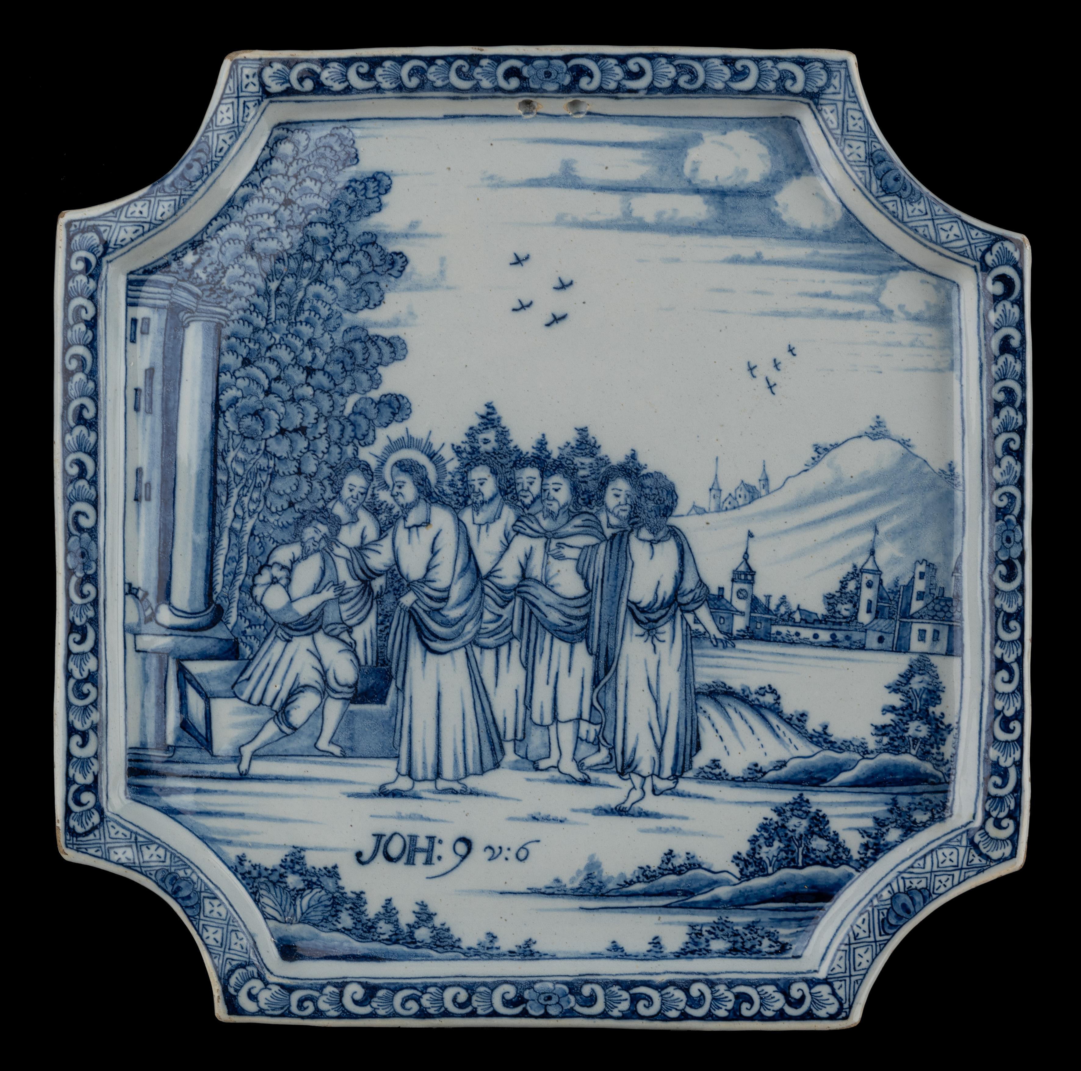 Plaque biblique bleue et blanche. Delft, 1740-1760 

La plaque carrée a des coins dentelés, un bord plat en relief et est peinte en bleu avec un décor biblique  dans un paysage vallonné.  L'inscription biblique Jean 9 v.I.6 figure au premier plan.
