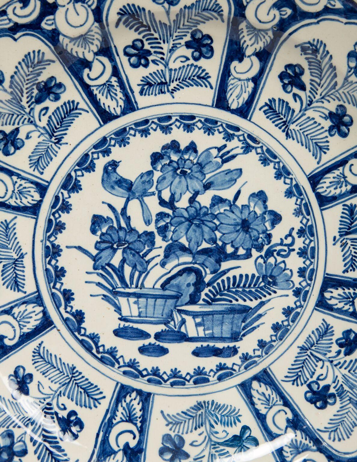 We are pleased to offer this hand painted, Dutch Delft blue and white charger. The charger is beautifully painted and attractively priced. The center of the charger is decorated with a songbird in a flowering garden. Around the central scene are