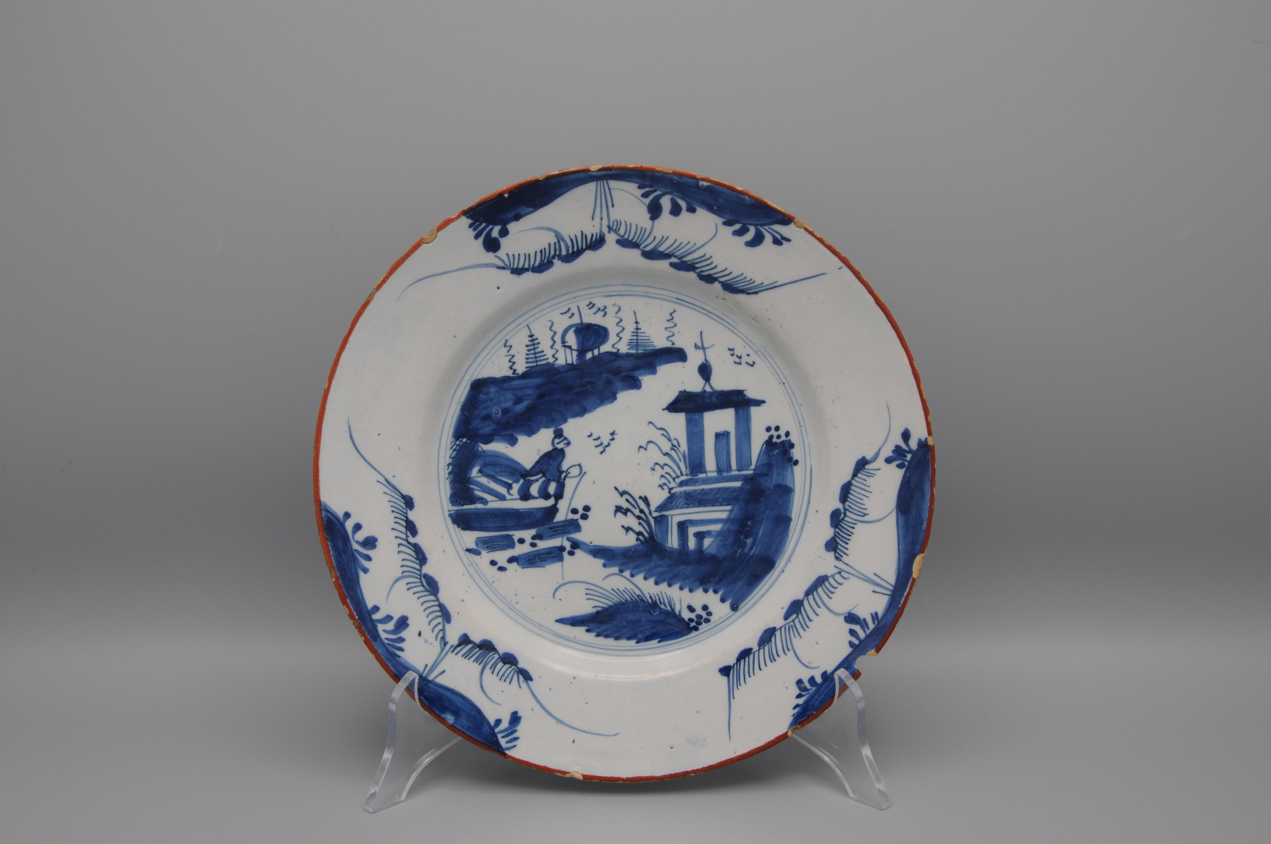 Plato de Delftware azul de mediados del siglo XVIII con decoración chinoiserie de un pescador y un pagode. 
Borde marrón estilo Qianlong
Sin marcar

Buen estado antiguo; algunos pequeños desconchones y el desgaste habitual en el borde. Una ficha más
