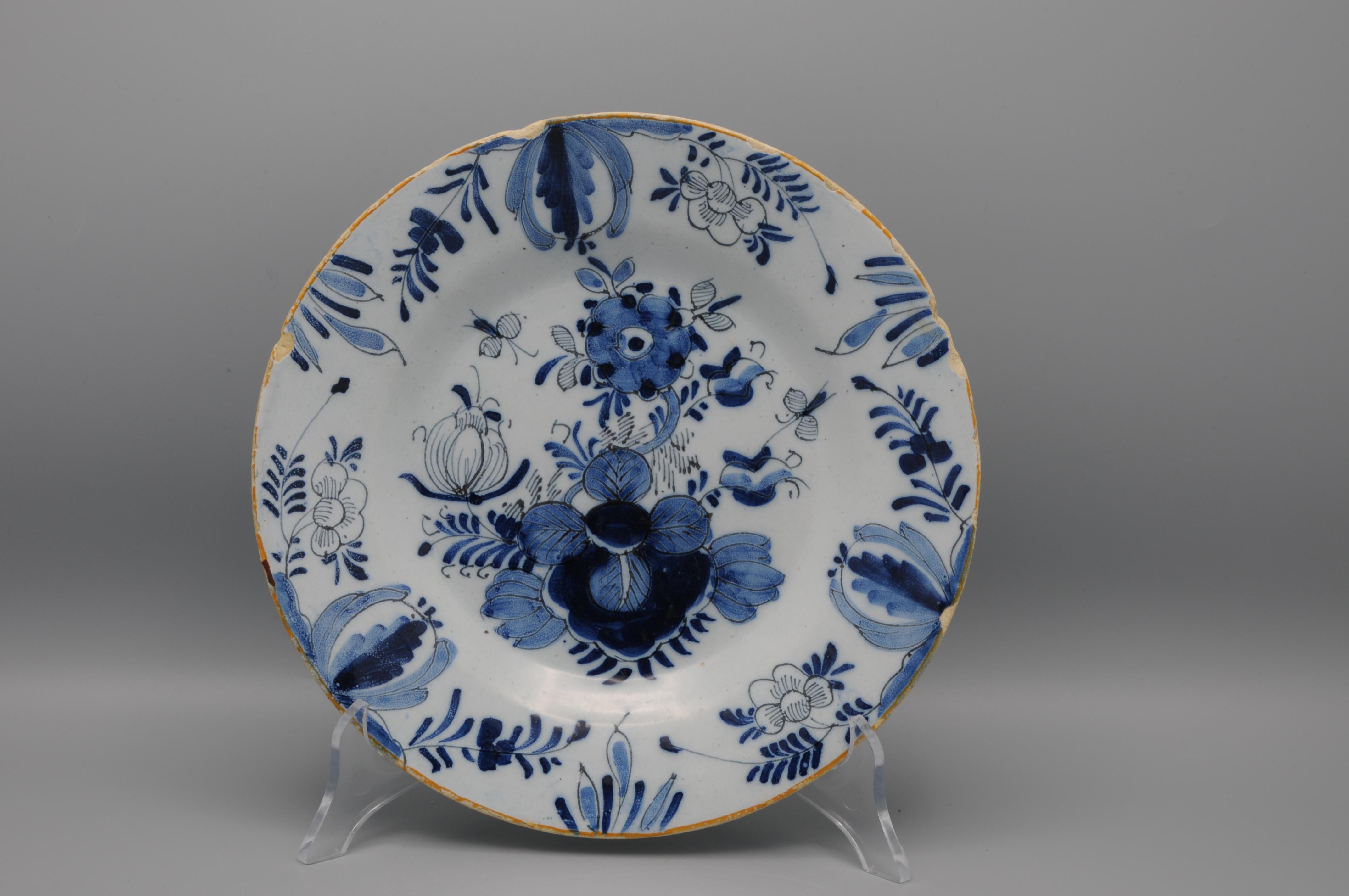 Assiette en faïence bleue du milieu du XVIIIe siècle avec un décor d'inspiration chinoise composé de fleurs et d'insectes. 

Condit : quelques rayures et usures. Quelques ébréchures sur le bord. 

Non marqué, seconde moitié du XVIIIe siècle
