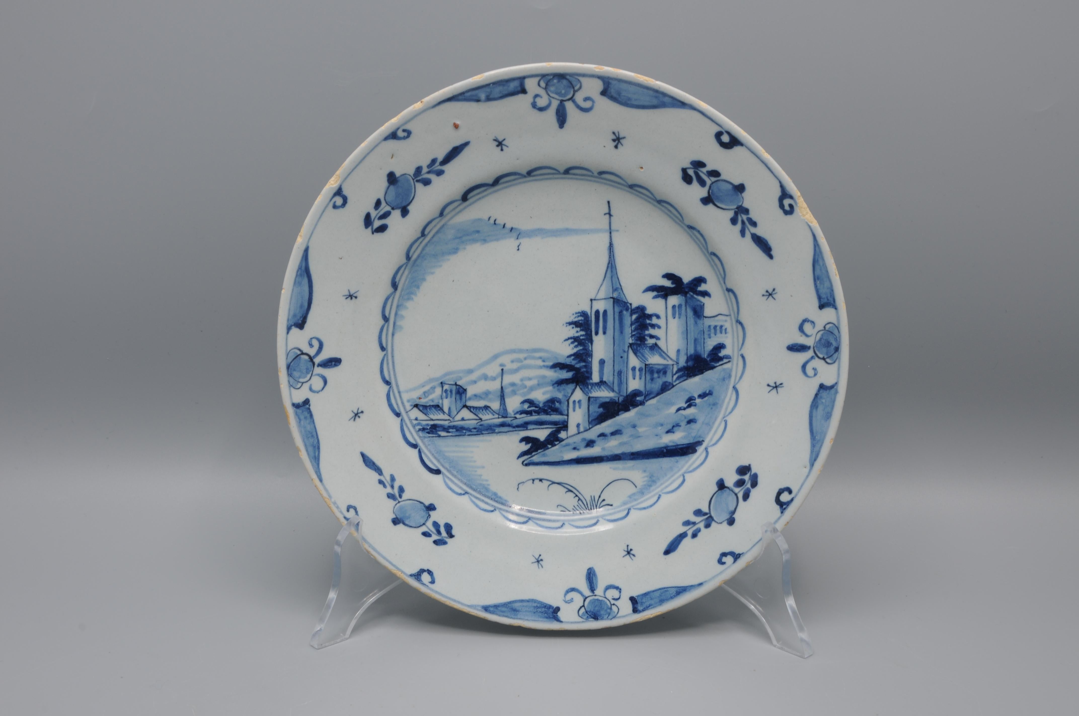 Assiette hollandaise en faïence étamée de la fin du XVIIIe siècle illustrant la tradition Delftware, remarquable par sa décoration caractéristique en bleu cobalt sous glaçure sur fond blanc. 


La composition centrale présente un paysage peint