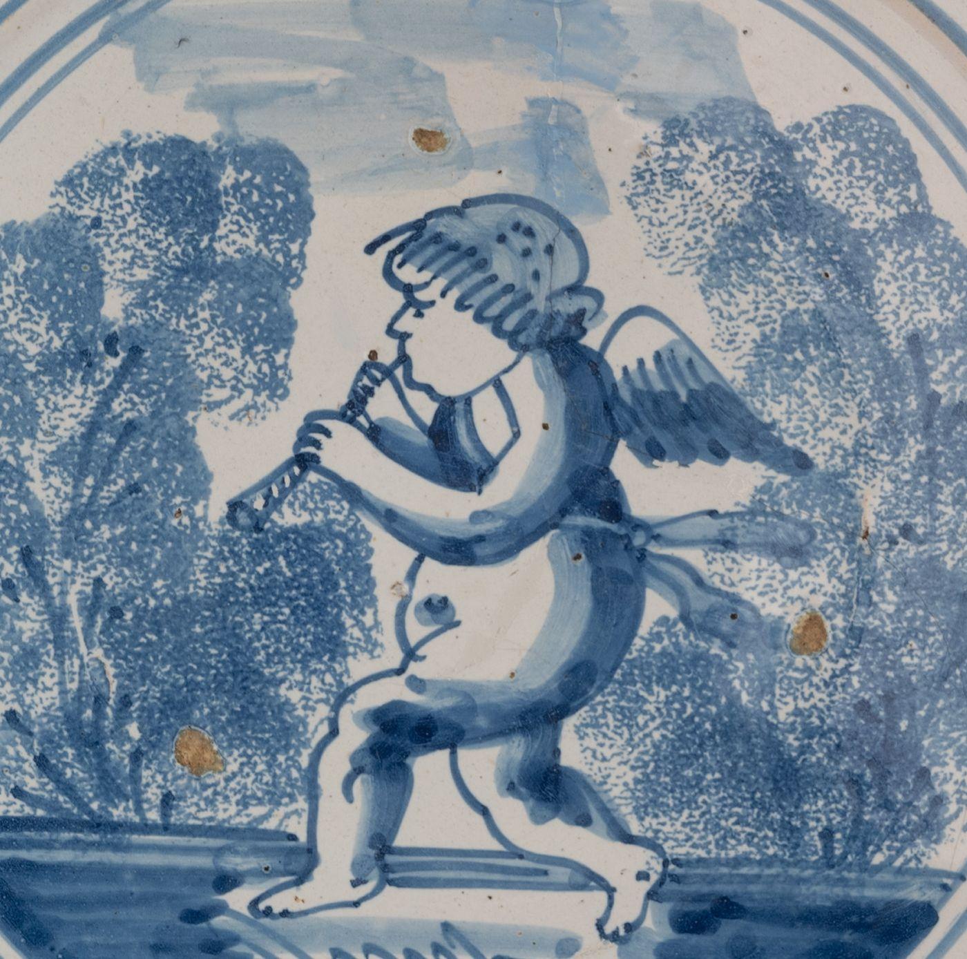 Baroque Delft Blue and White Dish with a Flute-Playing Putto, the Netherlands, 1660-1700 For Sale