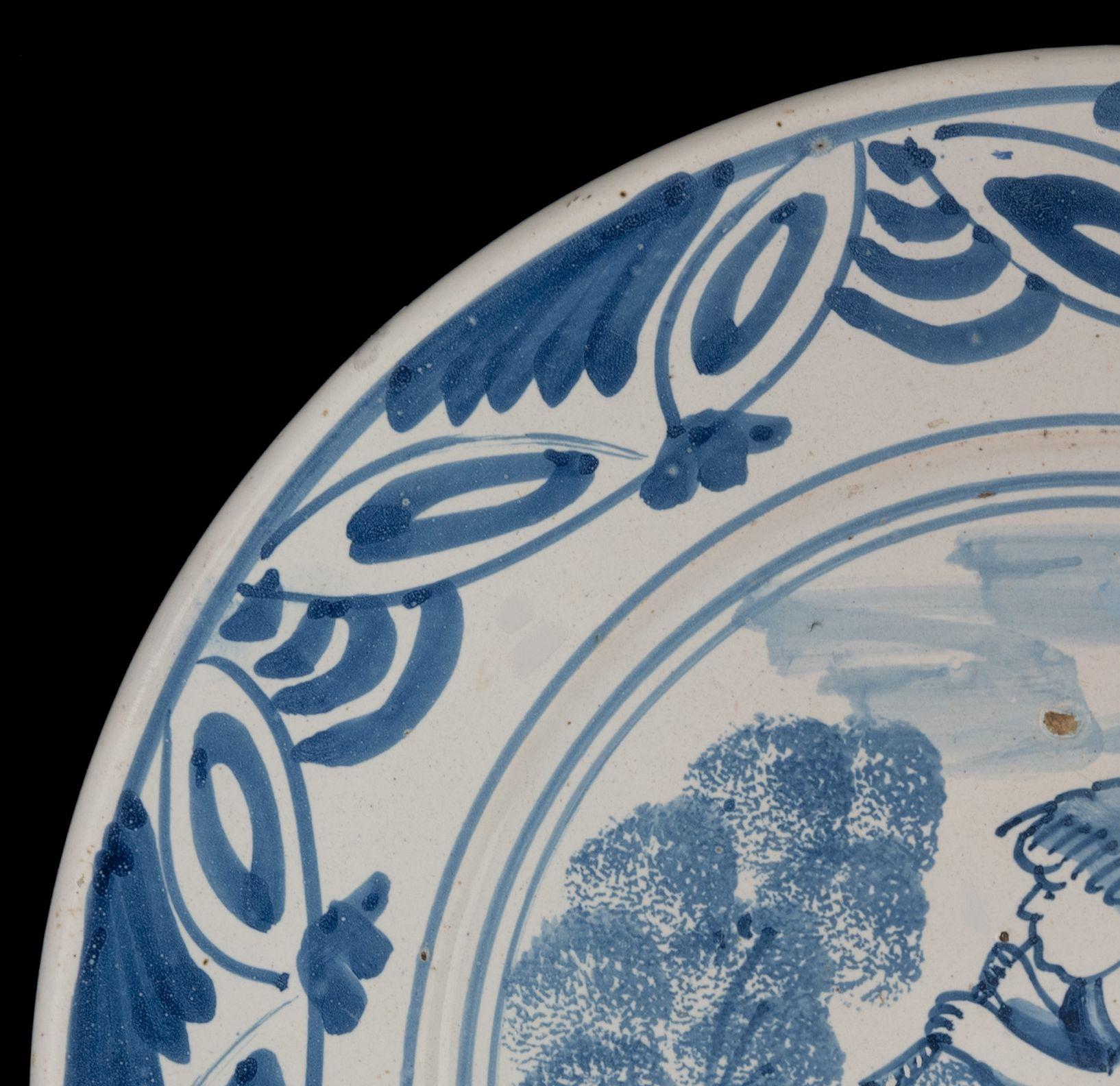 Dutch Delft Blue and White Dish with a Flute-Playing Putto, the Netherlands, 1660-1700 For Sale