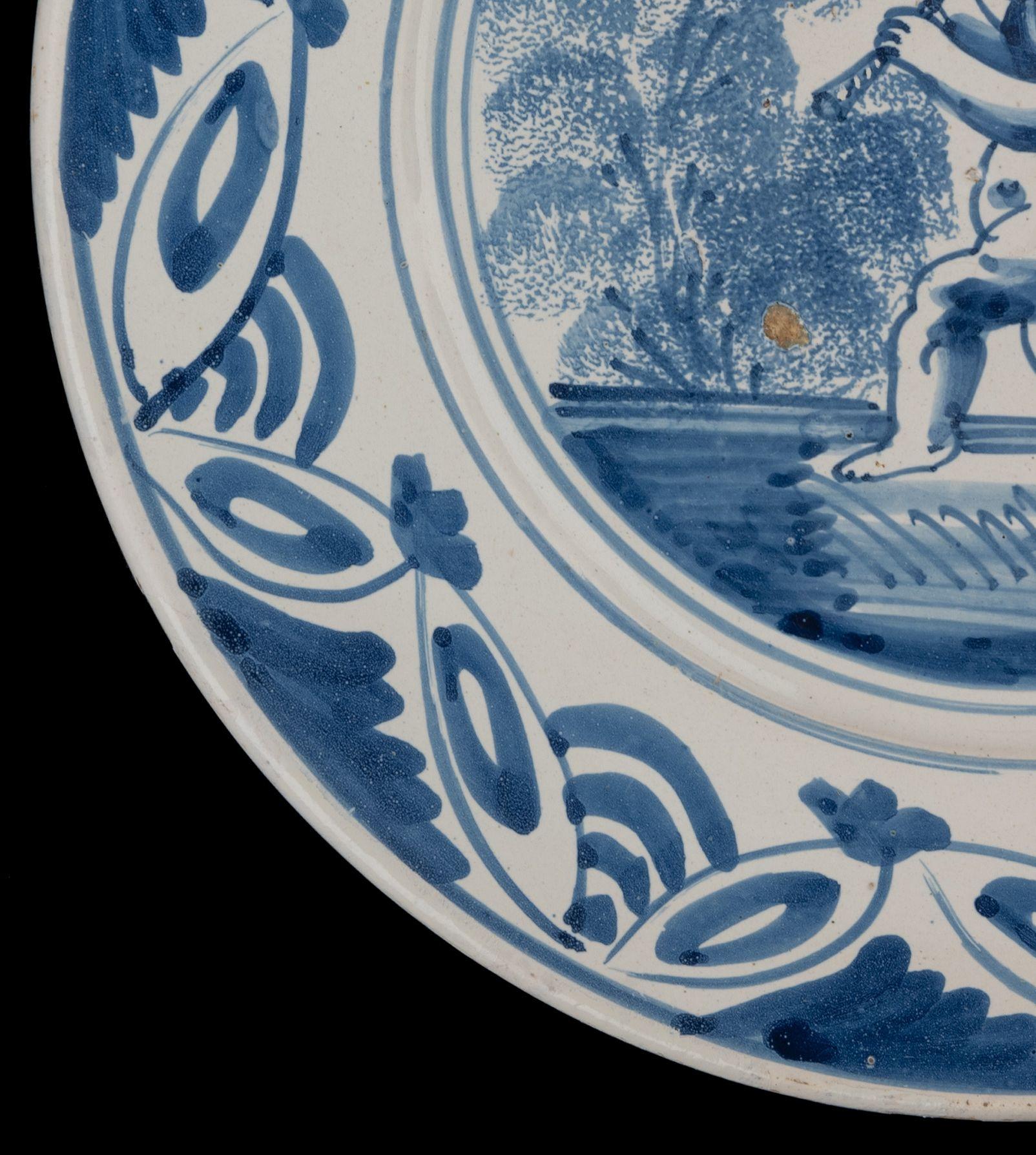 17th Century Delft Blue and White Dish with a Flute-Playing Putto, the Netherlands, 1660-1700 For Sale