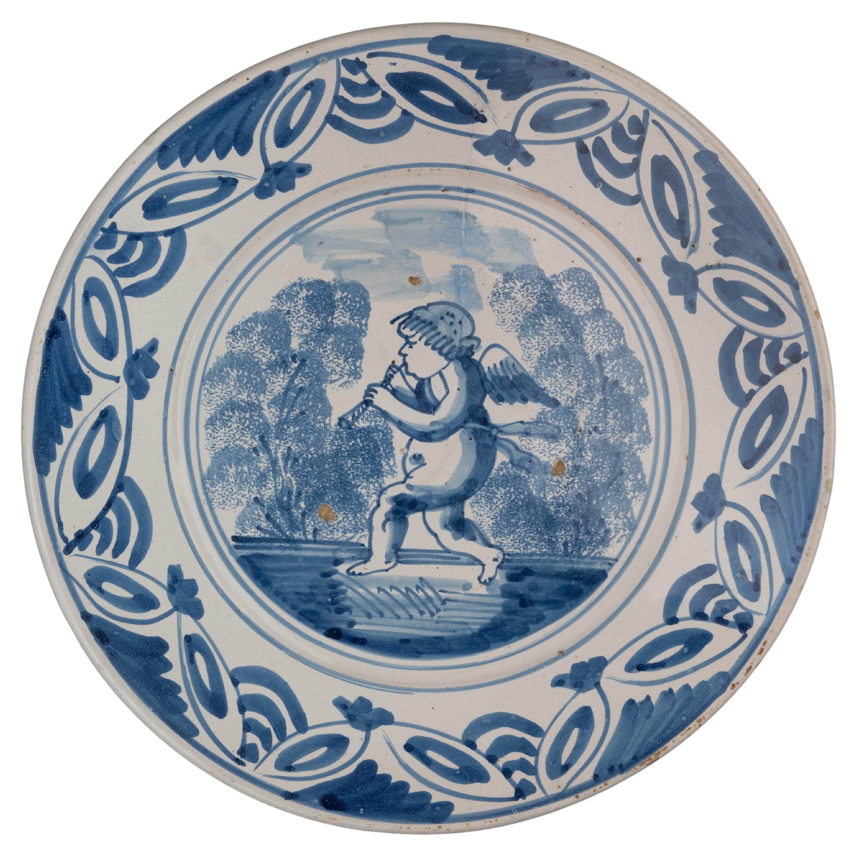 Delft Blue and White Dish with a Flute-Playing Putto, the Netherlands, 1660-1700 For Sale