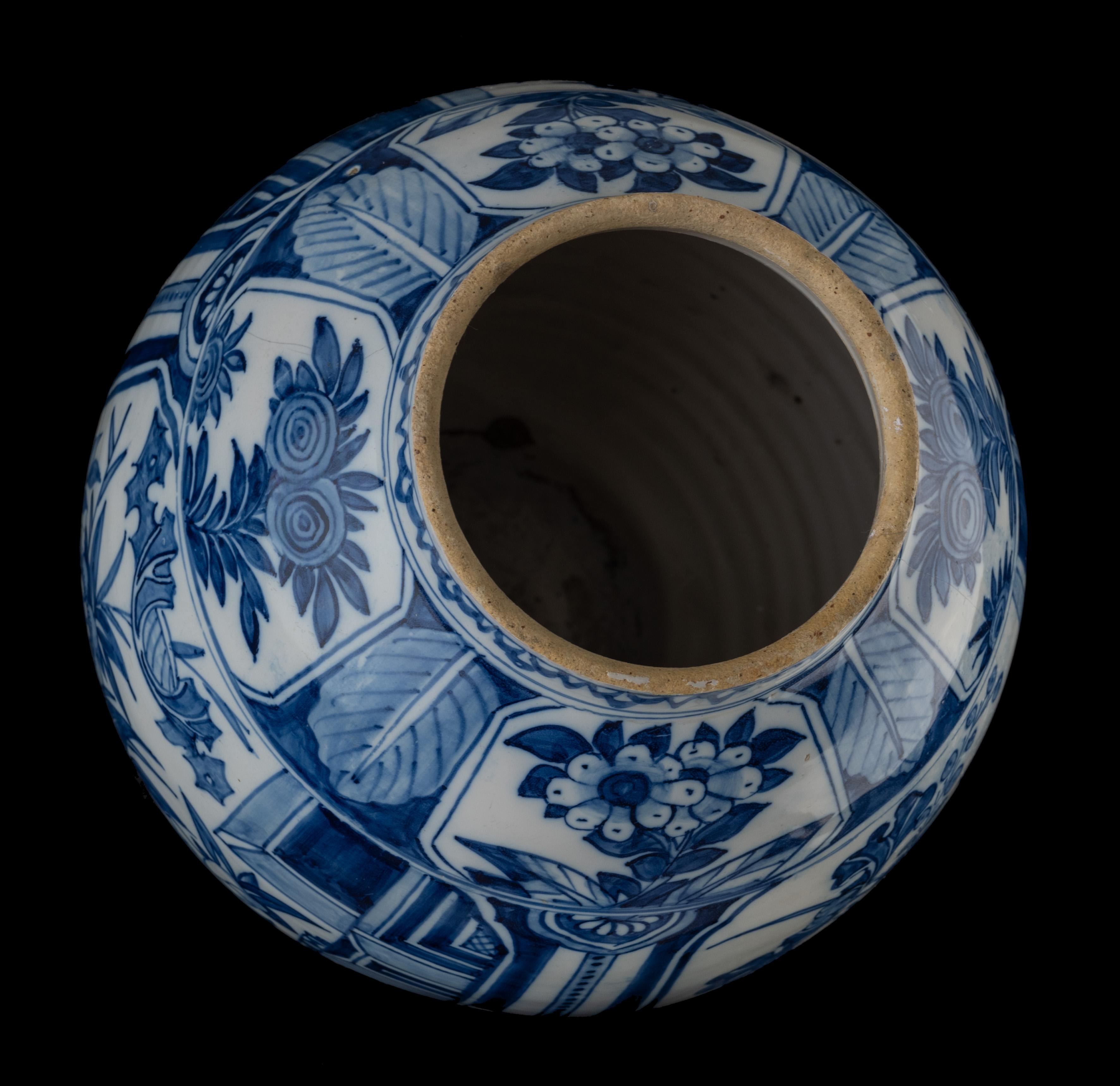 The ovoid jar stands on a slightly spreading foot, has a short upright neck, and is painted in blue with a floral decor. Three large cartouches containing flower bouquets have been applied to the belly, separated from each other by panels with
