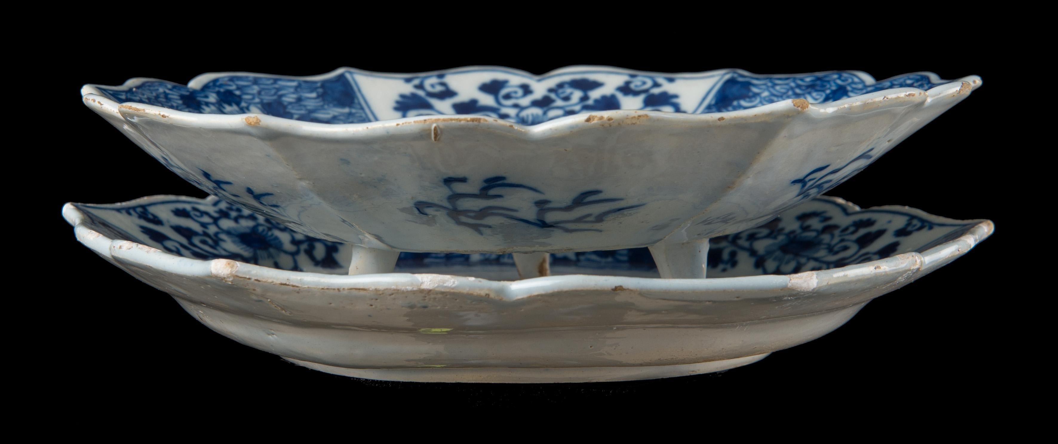 Blue and white fruit dish on stand.
Delft, 1740-1760 The Porcelain Claw pottery mark: a claw and number 70.
The hexagonal fruit dish and stand have scalloped accolade-shaped rims. The dish stands on three feet and is pierced with a star in a