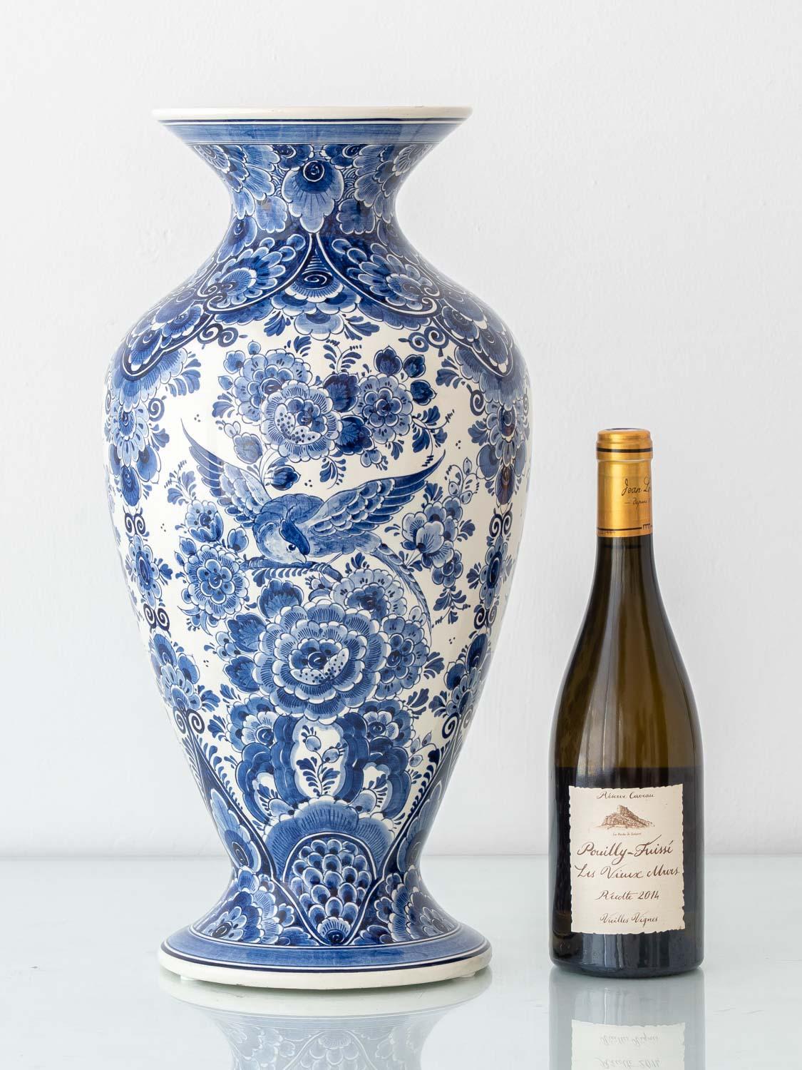Este jarrón alto azul de Delft es un sorprendente ejemplo de la loza pintada a mano de Velsen de mediados de siglo, ejecutado con una refinada silueta de balaustre que se ensancha suavemente en el cuello y el pie mientras se estrecha por todo el