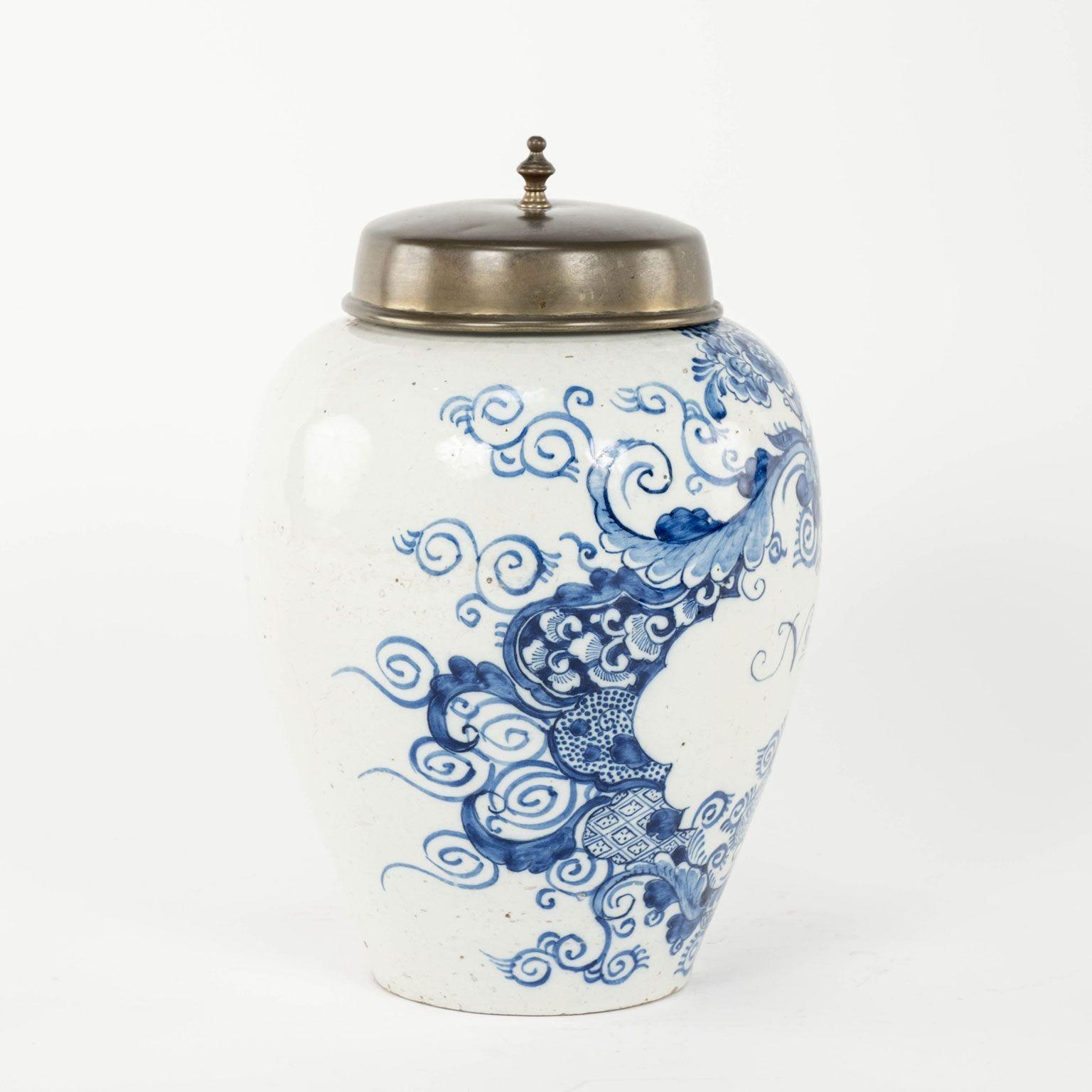 Delft blue and white No 8 tobacco jar circa 1790-1809. Urn-shape jar with brass lid from the Netherlands. In faience with blue painted leaf medallion labeled 