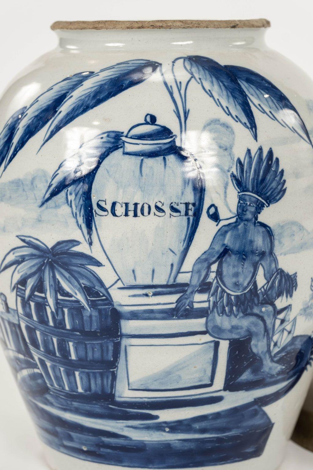 Delft blue and white “Schosse” urn-shape tobacco jar with lid, Netherlands, circa 1780. Decorated with coastal scene and seated “Amerindian” figure. Simple low brass lid with excellent patina and turned-style knob handle.

Note: Original/early