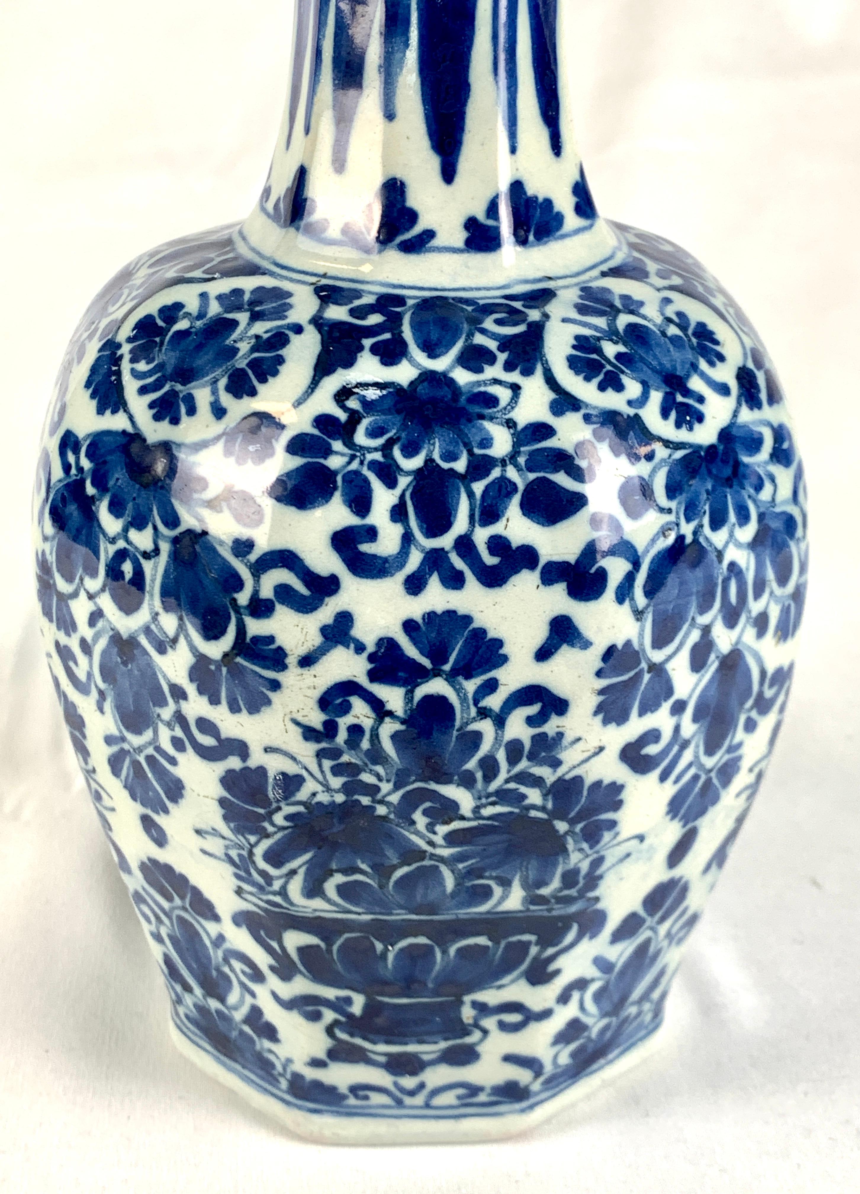 Made circa 1780, this 18th century Dutch Delft vase was hand painted with floral decoration of flowers and scrolling vines. 
A beautiful deep cobalt blue covers most of the surface.
The vase has a traditional Dutch Delft shape; an octagonal base