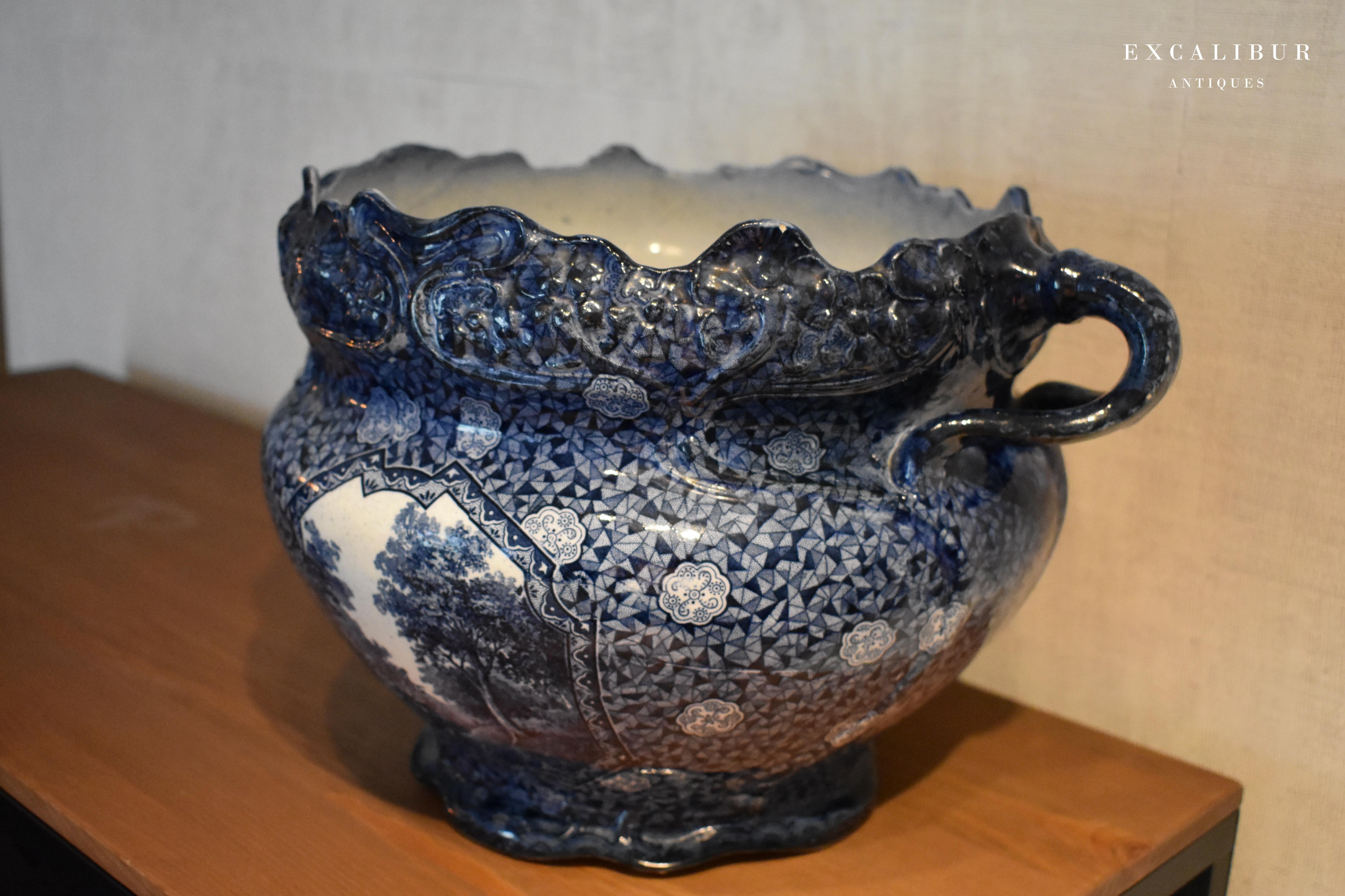 This large flower bowl is painted in the typical Dutch Delft blue style and has a beautiful decorative shape. It has a very small tear on the inside, and a small chip on the back of one of the handles. 