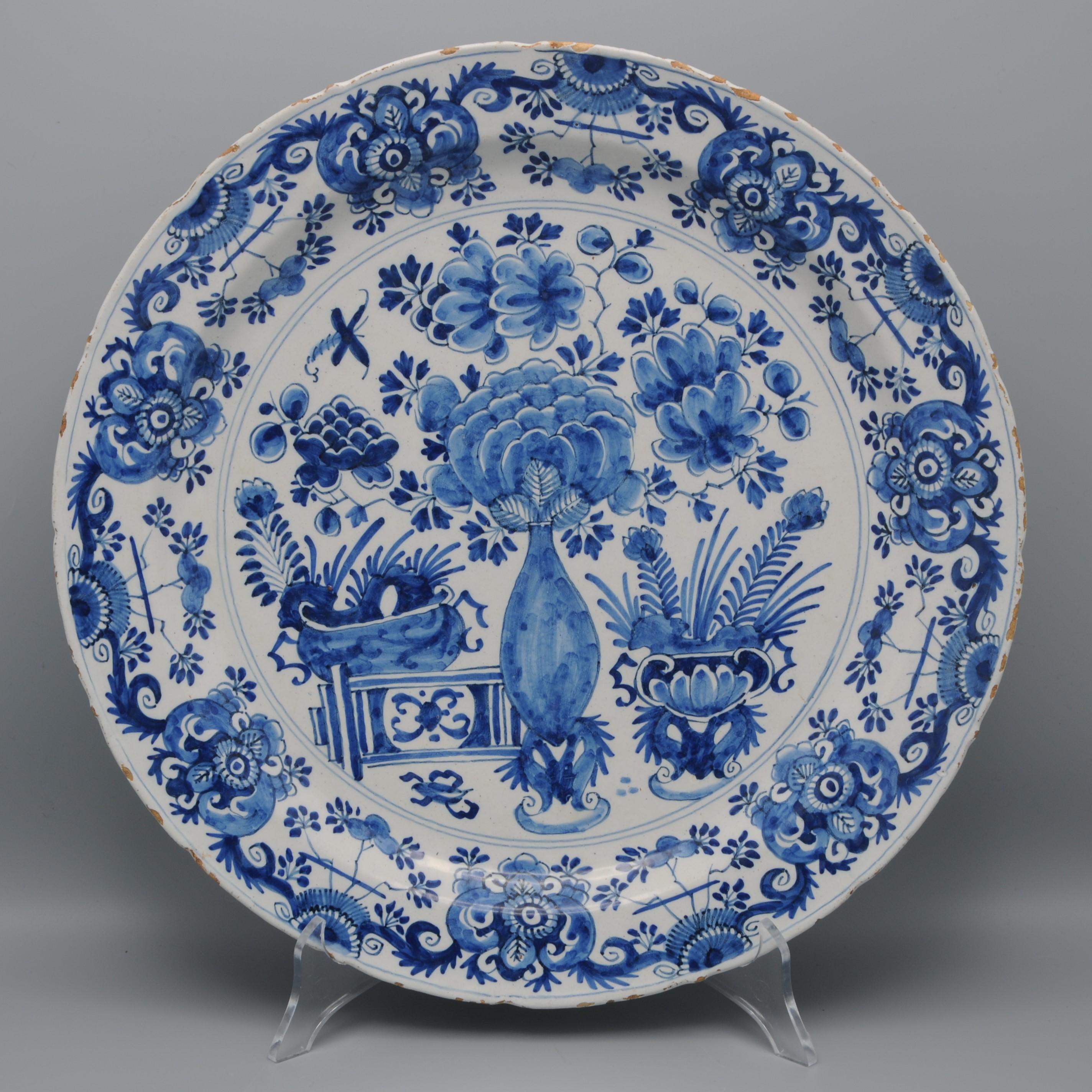 Plato de Delftware azul del siglo XVIII con elaborada decoración chinoiserie de tres cestas de flores. Hermosa ornamentación de ricos follajes, flores y volutas. Borde ligeramente escalonado. Color azul fuerte. 

Sin marcar. 
Buen estado, algunos