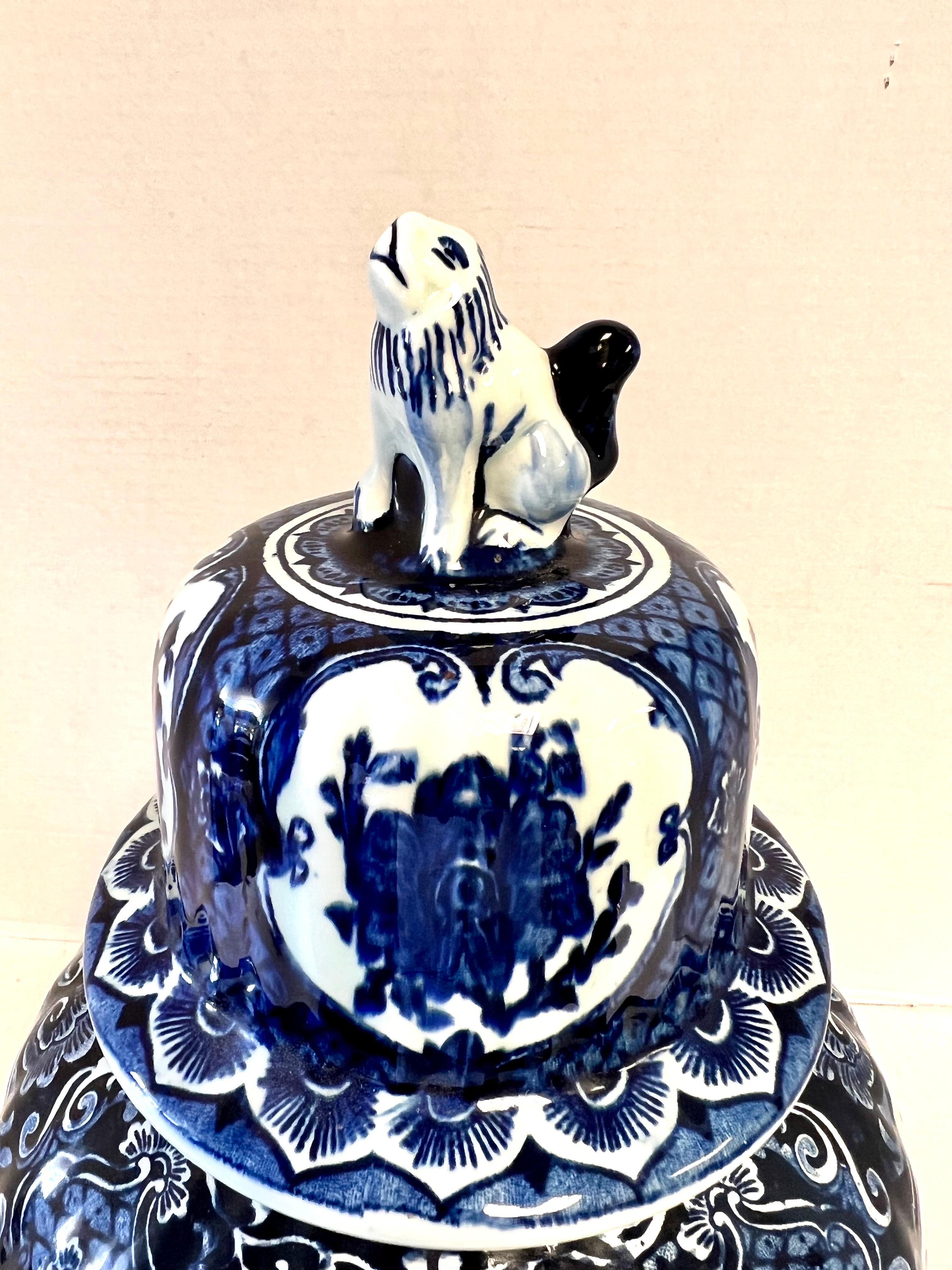 Delft chinoiserie style covered urn entirely hand painted with a floral motif all around and topped with a foo dog. Marked on underside. Perfect addition to your collection.