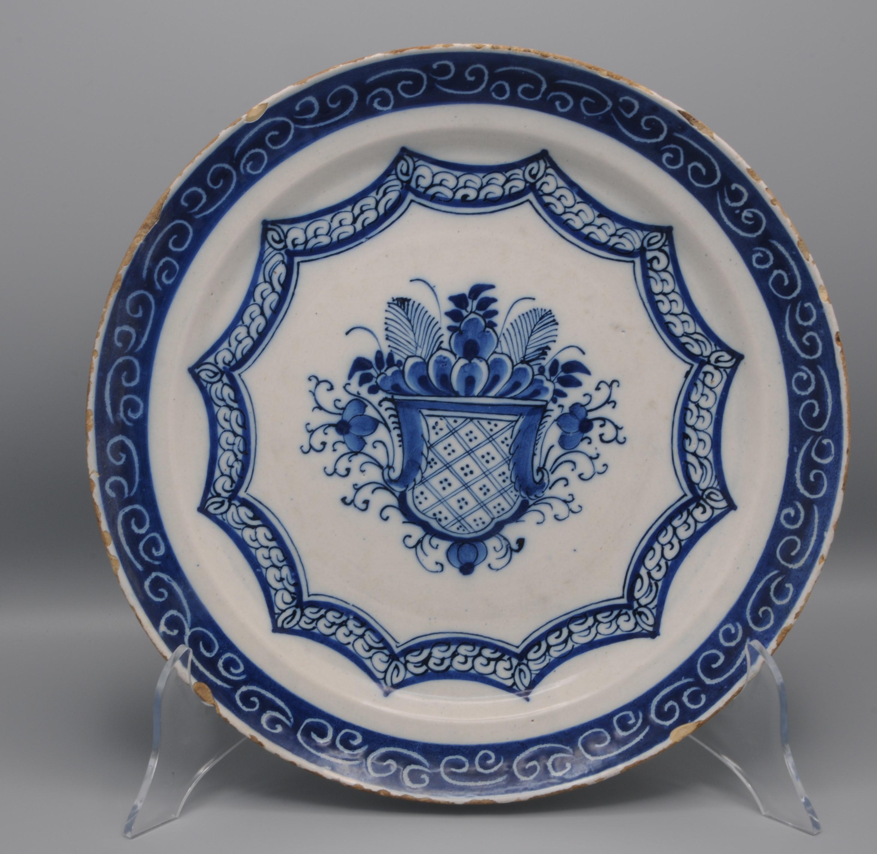 Mid 18th century Blue Delftware platter with Daniel Marot style decoration of a shield amidst flowers and foliage scrolls within a dodecagoon. 
Beautiful border decoration in rich blue with scrolls in 'spare-technique'.
Unmarked
Good quality of