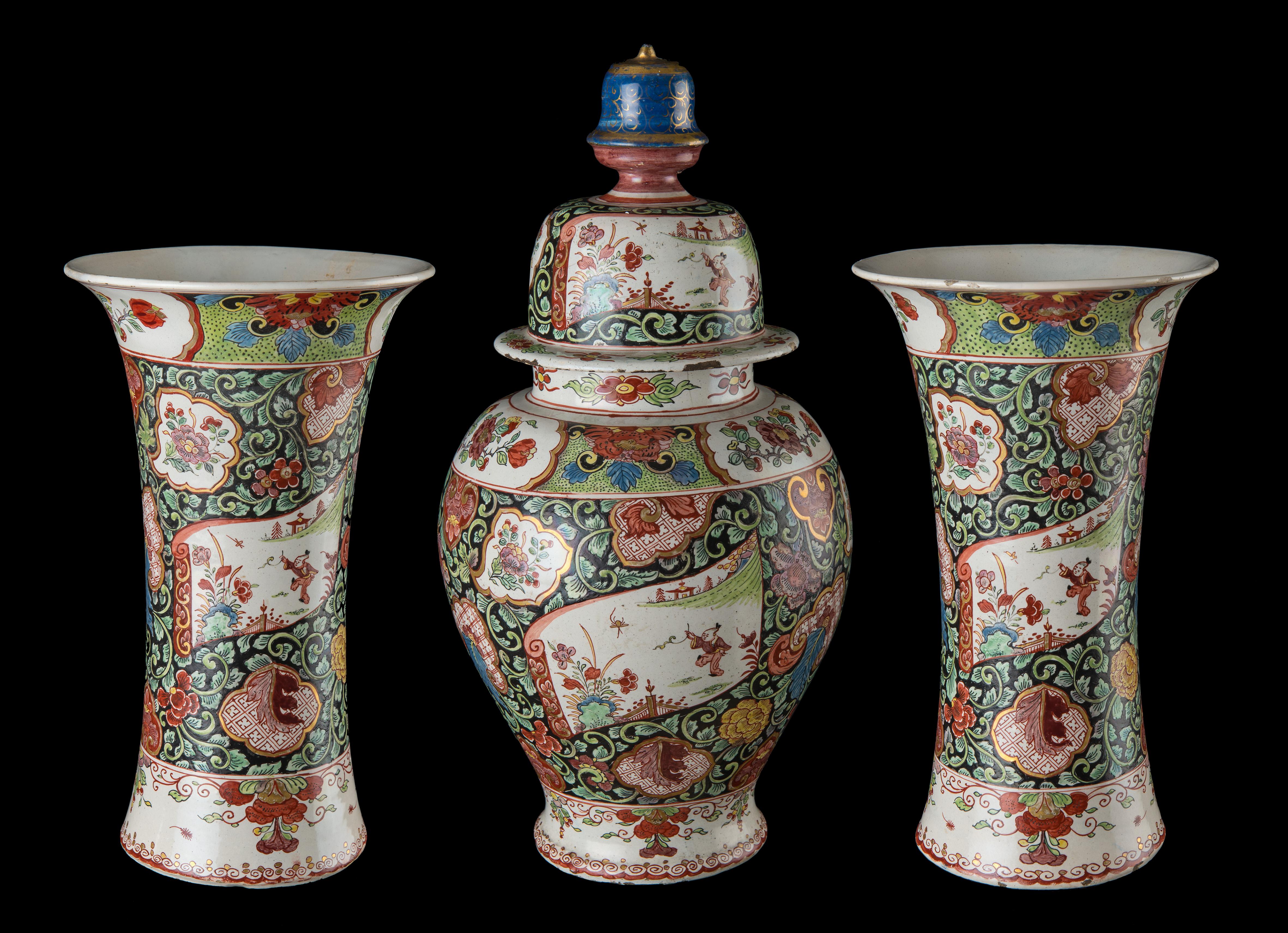 3 piece chinoiserie Famille rose garniture, Delft, 1730-1740

This petit feu garniture consists of a baluster vase with cover and two beaker vases. The cover has a bell-shaped knob. The baluster vase is decorated with three scroll-shaped panels,