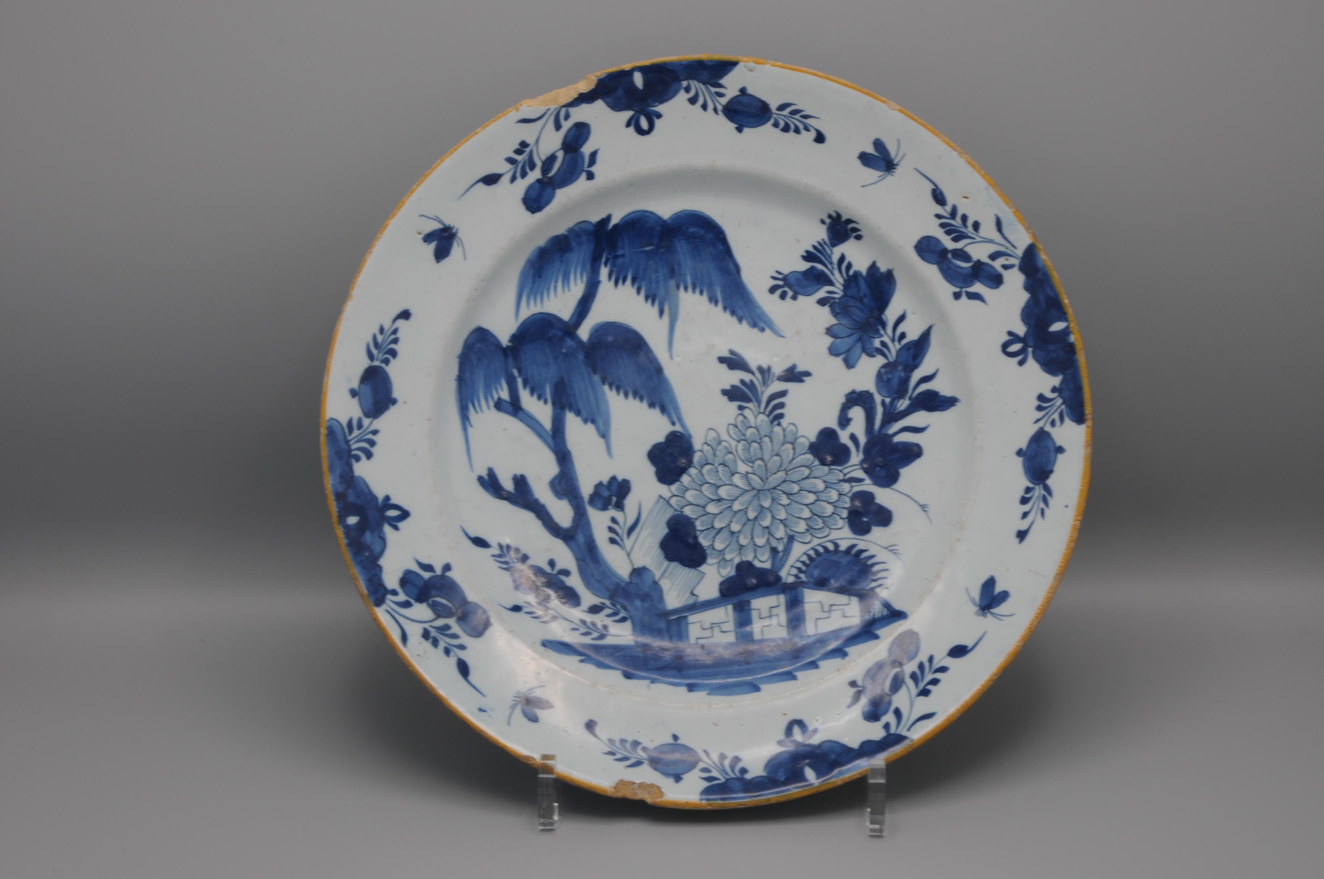 Assiette en faïence bleue du milieu du XVIIIe siècle à décor chinois d'une floraison de pivoines et d'autres fleurs derrière une clôture au milieu d'arbustes. Style Qianlong
Marqué d'une griffe pour la fabrication 