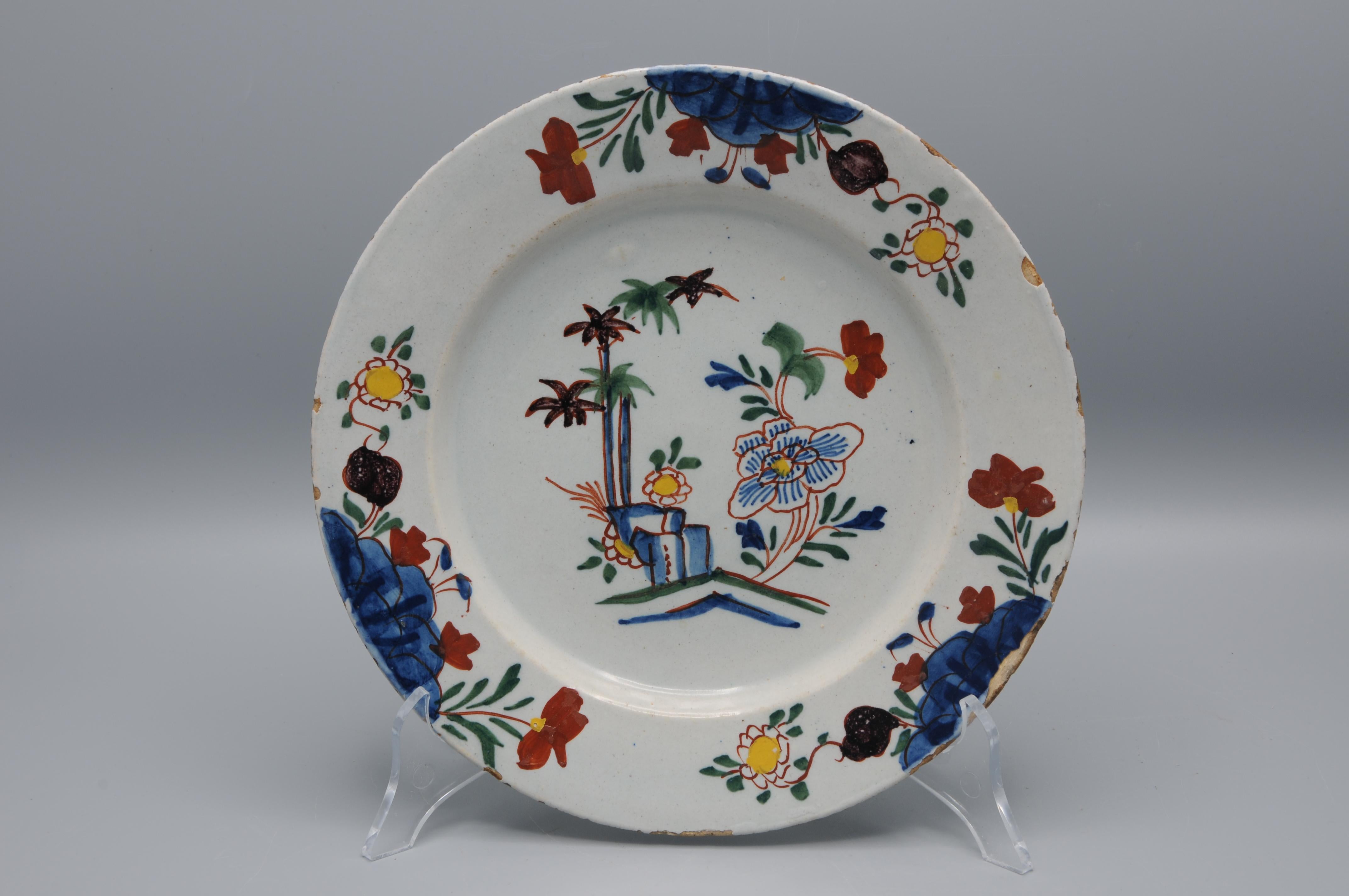 Mid-18th century Delft earthenware plate (faience) featuring hand-painted polychrome decoration in the popular Chinoiserie style, reflecting European interpretations of Chinese porcelain motifs combined with the flowing, asymmetrical designs