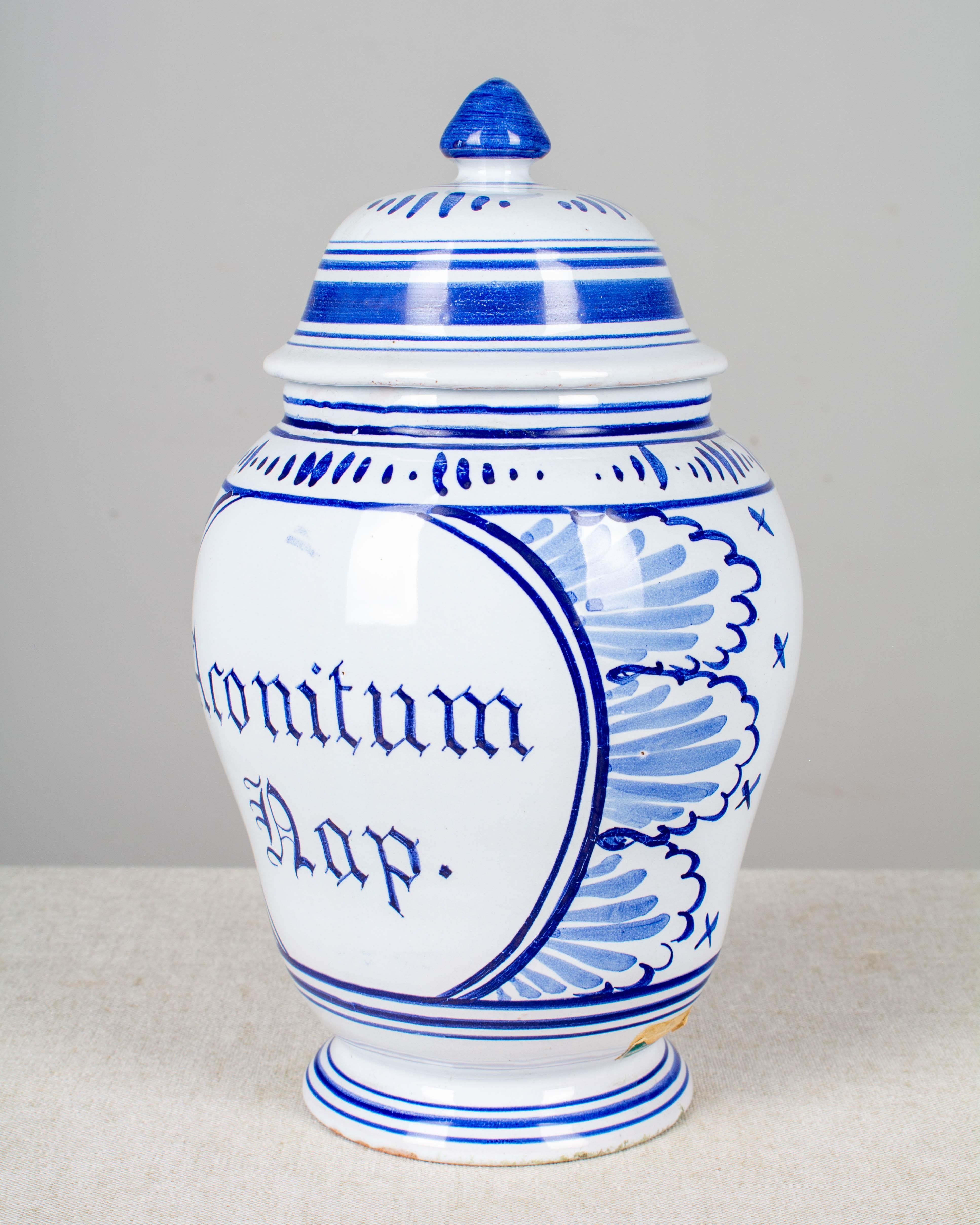 A delft faience apothecary jar with blue hand painted decoration and label: Aconitum Dap. Unmarked. Remnants of green foil label near the base.