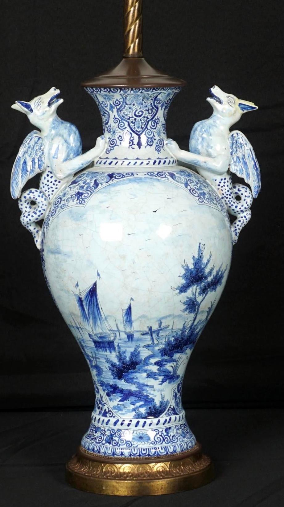 Delft Faience figural Serpent handle lamp. 18th century Dutch baluster form blue and white faience decorated vase with winged serpent handles, floral and foliate decorated with seaside scene one side, man and woman milking a goat in the opposite