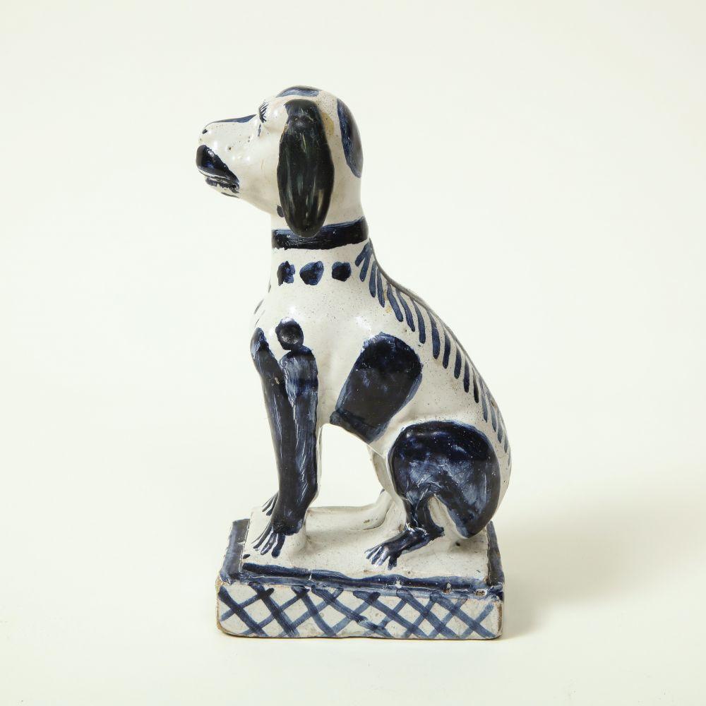 Faience, dipinto di blu. Con schienale spinoso e seduto su una base rettangolare con scanalature trasversali.