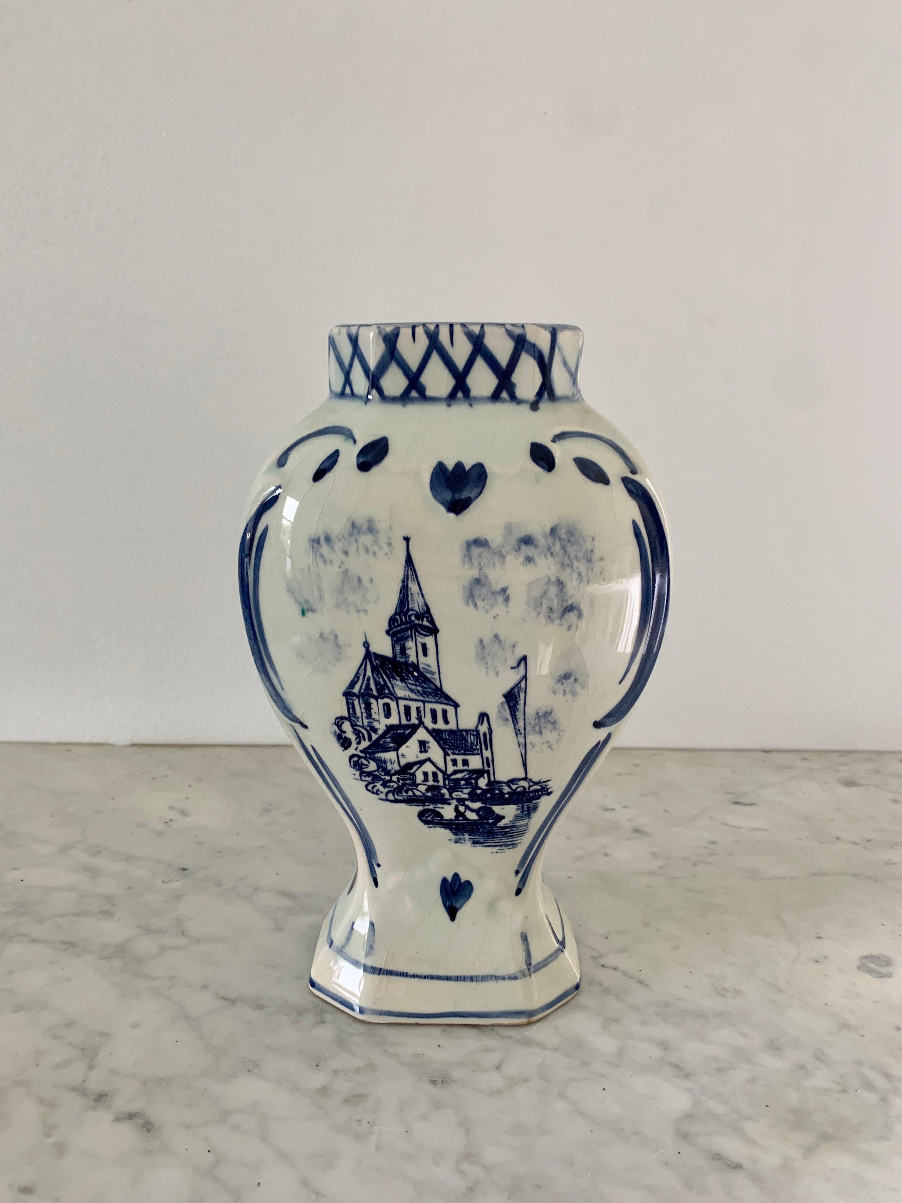 A beautiful hand painted blue and white Delft porcelain vase with a painted village scene

Holland, Circa 1960s

Measures: 5.75