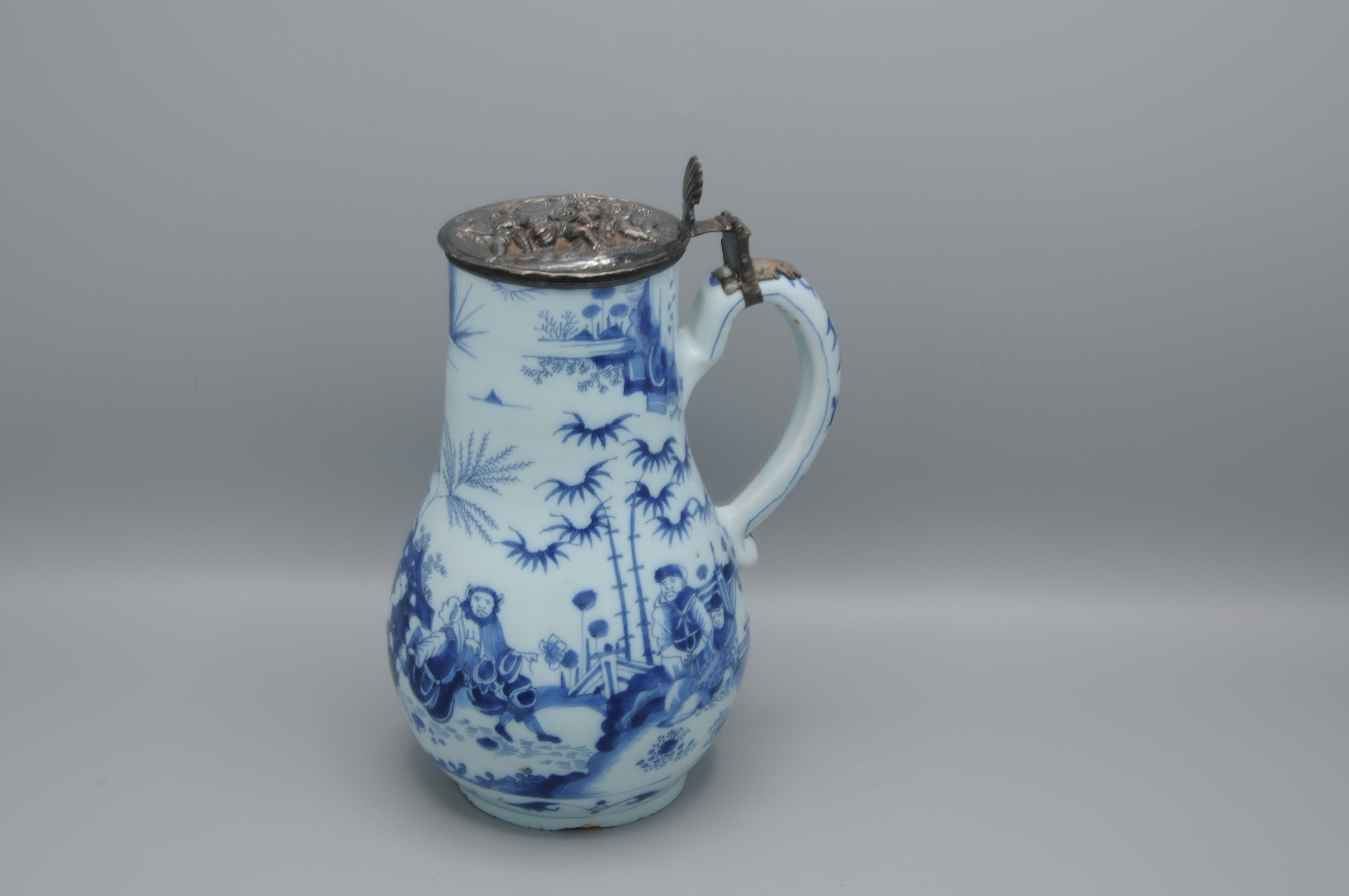 Pear-shaped jug, decorated in the Chinese transition style depicting figures in an oriental landscape. Silver cover depicting putti. 

Provenance: Ex-collection of Dionydia Wilhemina Everwijn (1923-2011). 
Property of the Stilte-Stiching Landgoed