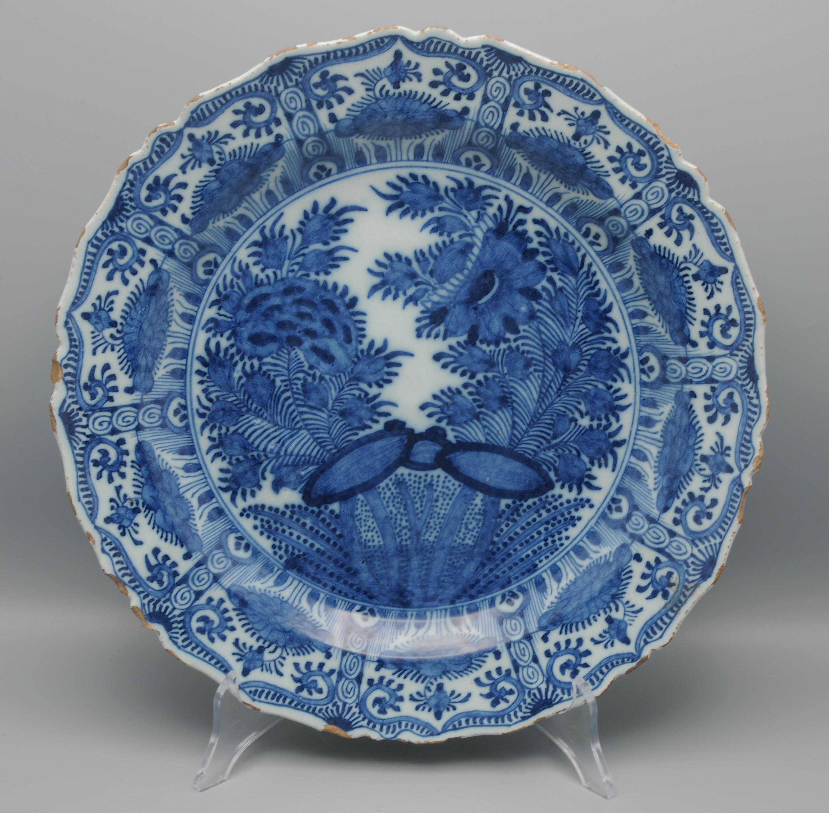 Dutch Delft Chinoiserie Kangxi Style charger depicting a Chinese garden. 
The rim with 10 fan-shaped panels 
Marked with an axe for 'The Porceleyne Bijl' (the Porcelain Axe) 1657-1803.



Good condition: light chipping and some usual wear to the rim