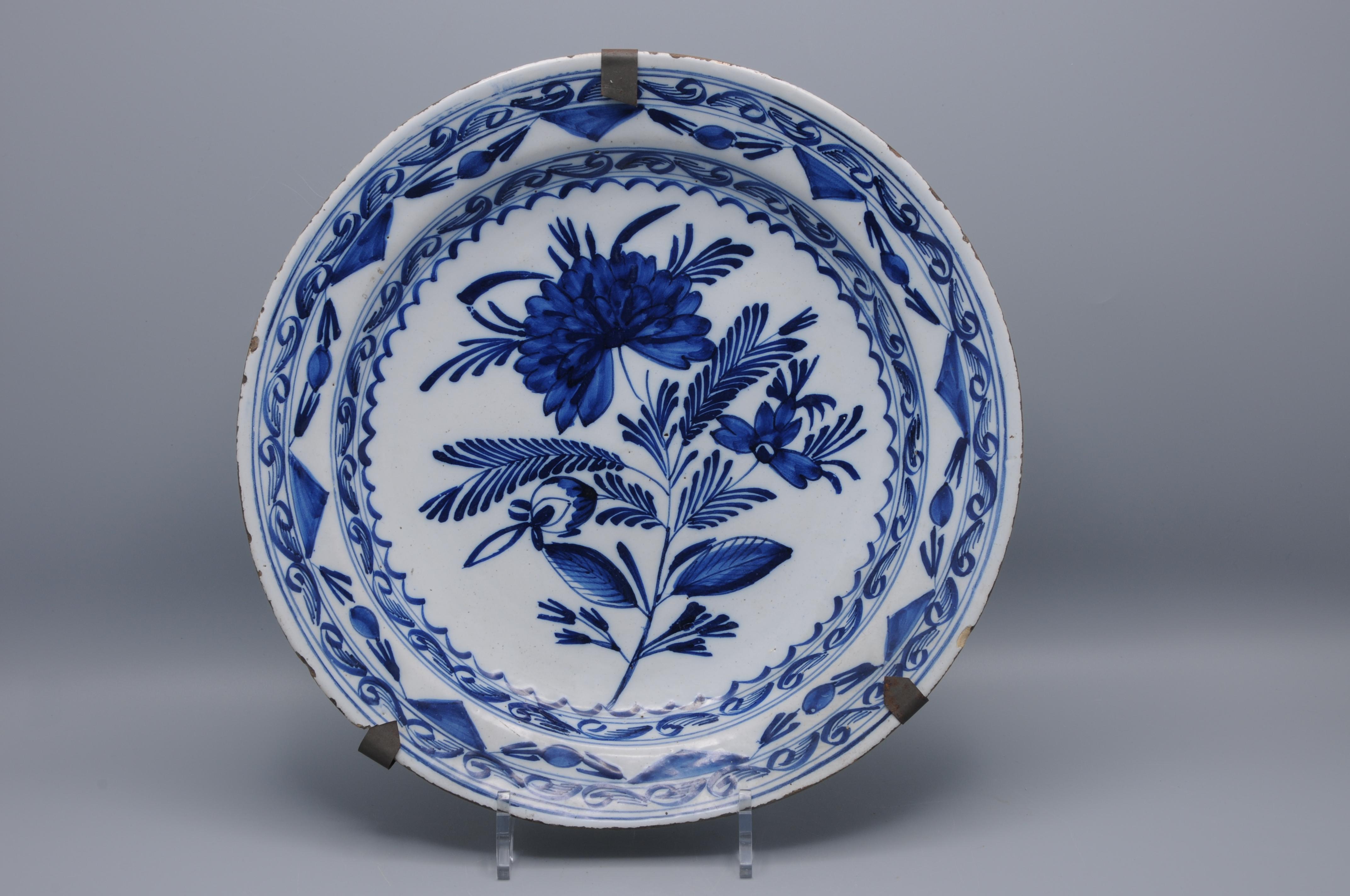 Chargeur en faïence hollandaise de la fin du 18e au début du 19e siècle, de style néoclassique, exécuté à la manière de Boerendelft. L'assiette est peinte à la main en bleu sous glaçure sur un fond blanc de glaçure à l'étain, avec un arrangement