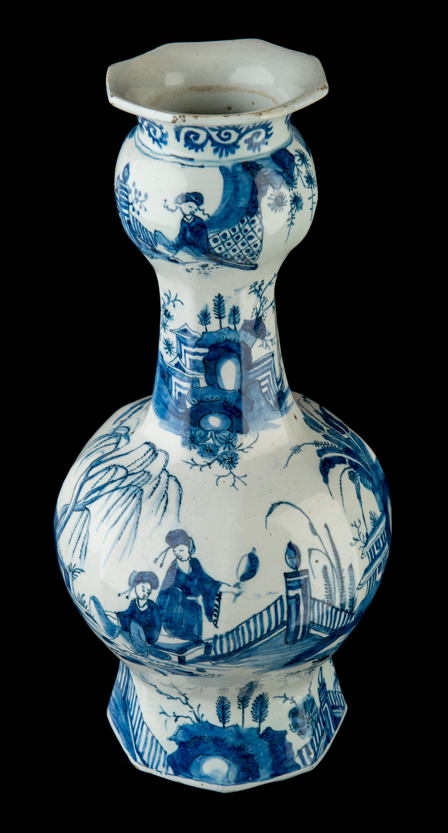 The octagonal bottle vases stand on a wide, spreading foot with a garlic neck over a spherical body ending in a trumpet-shaped mouth. The vases are painted with a continuous chinoiserie design. Around the foot, the body, the neck and the bulb four