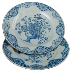 Delft Pareja de platos azules y blancos con jarrones de flores fechados en 1760