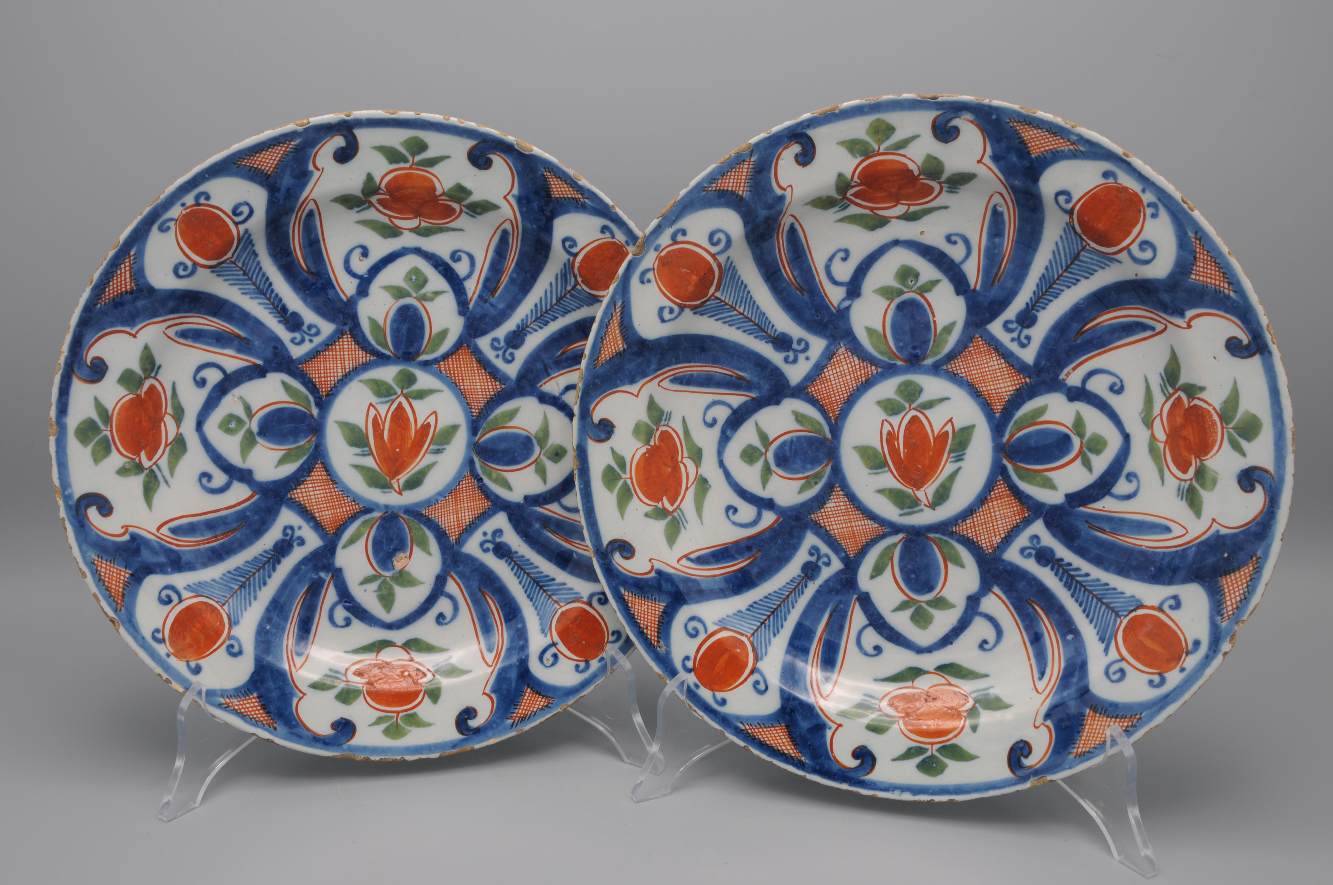 Pareja de platos de Delftware policromado de mediados del siglo XVIII con un tulipán central naranja y cuatro cartuchos con capullos de flores naranjas con hojas verdes. Colores muy vivos. 

marca: 