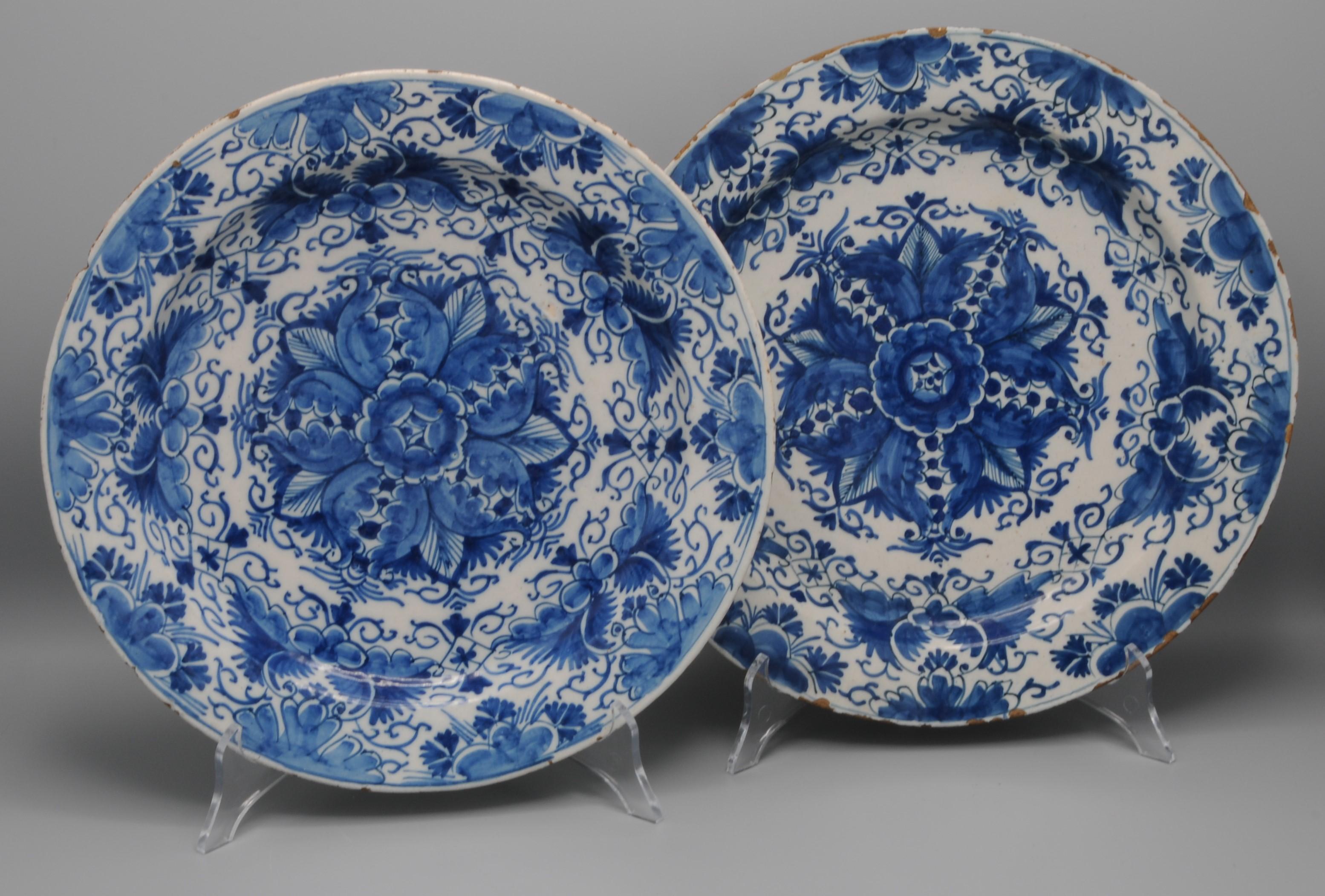 Excellent pair of mid 18th century Delftware plates with a rare geometrical decoration of a stylized flower with foliate scrolls. 
Border adorned with foliage scrolls and flower sprigs. 

Unmarked