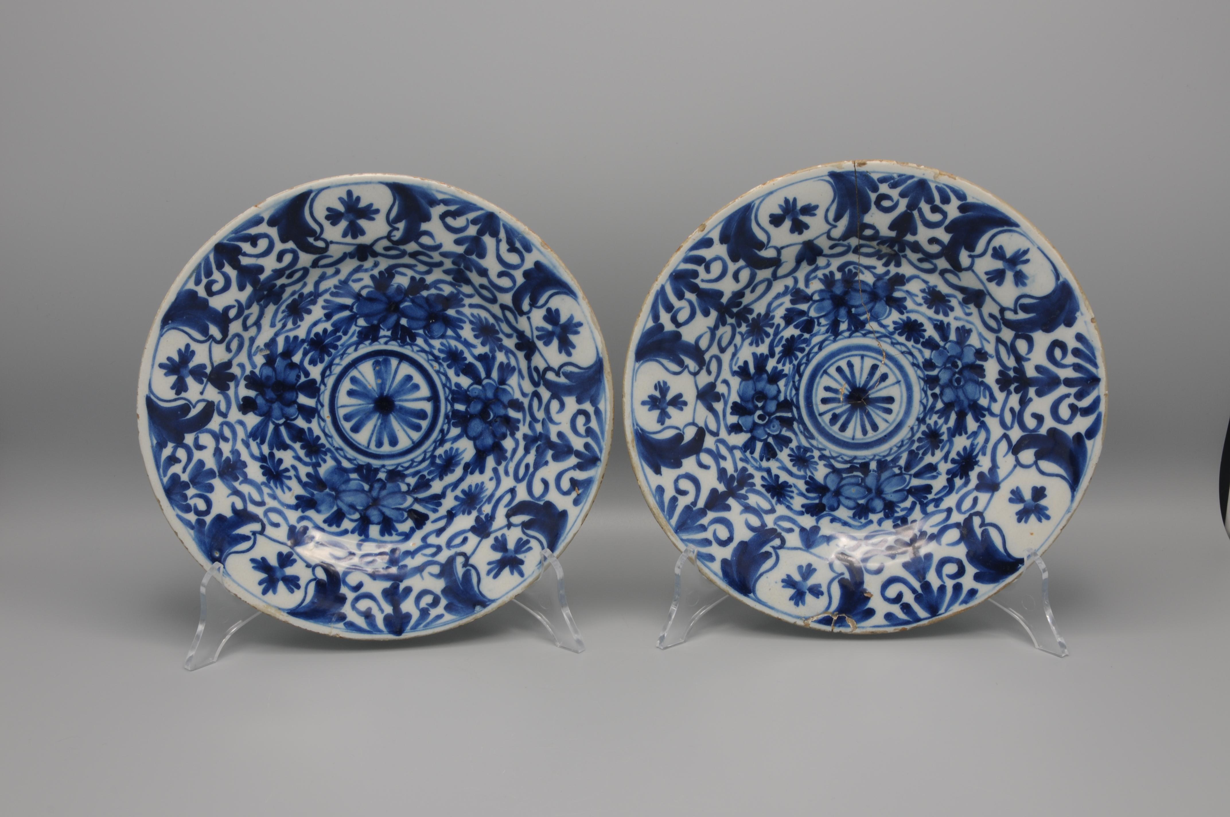 Pair of late 18th century Delftware plates with 'boerendelft' decoration.
Border adorned with foliage scrolls. 

unmarked
Condition: One in good condition, other with hairline and restored chip. 